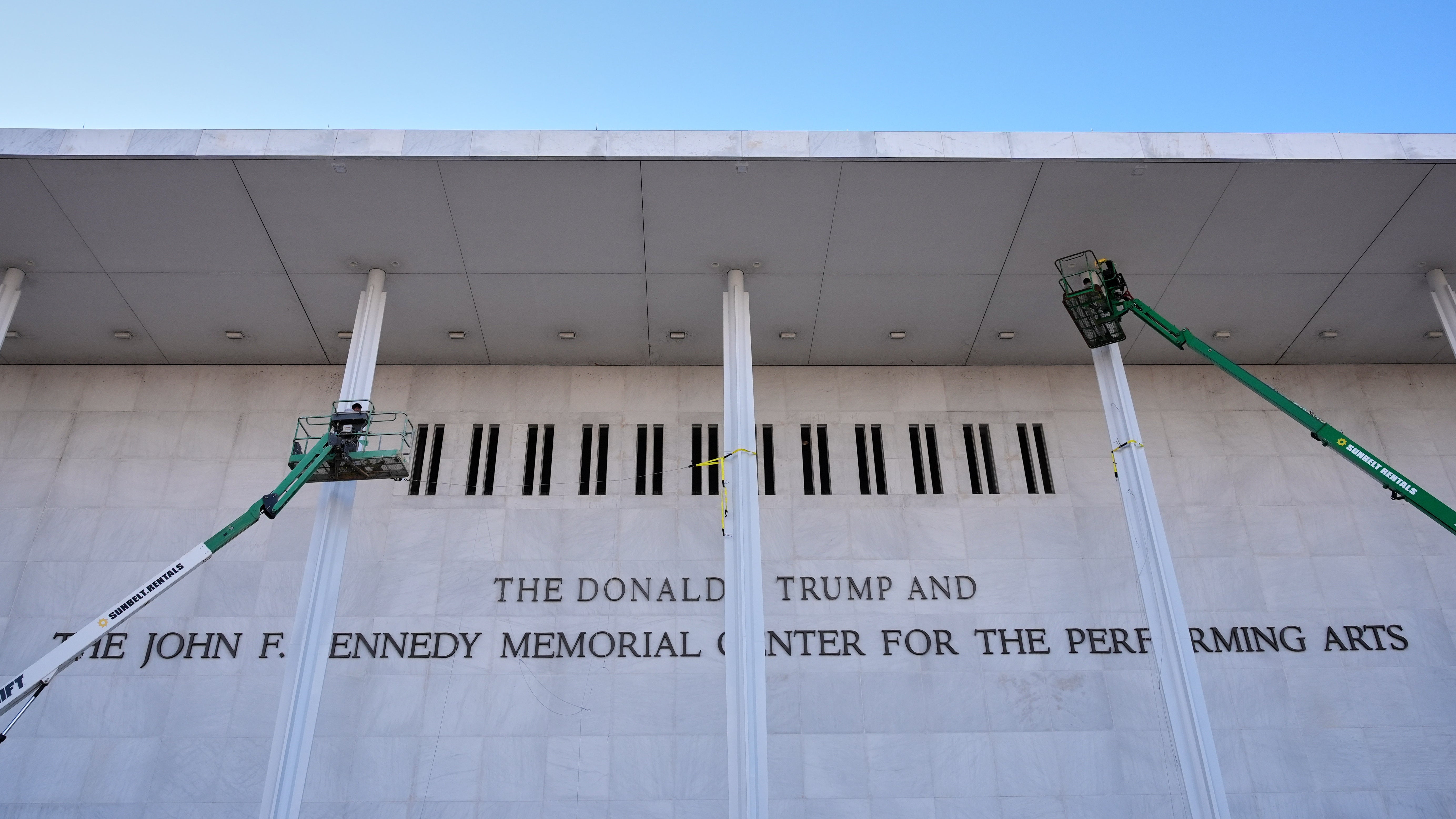 Workers add President Donald Trump’s name to the Kennedy Center in Washington, D.C. Kennedy Center President Richard Grenell has threatened to sue jazz musician Chuck Redd for canceling a holiday show in response to the venue’s new name