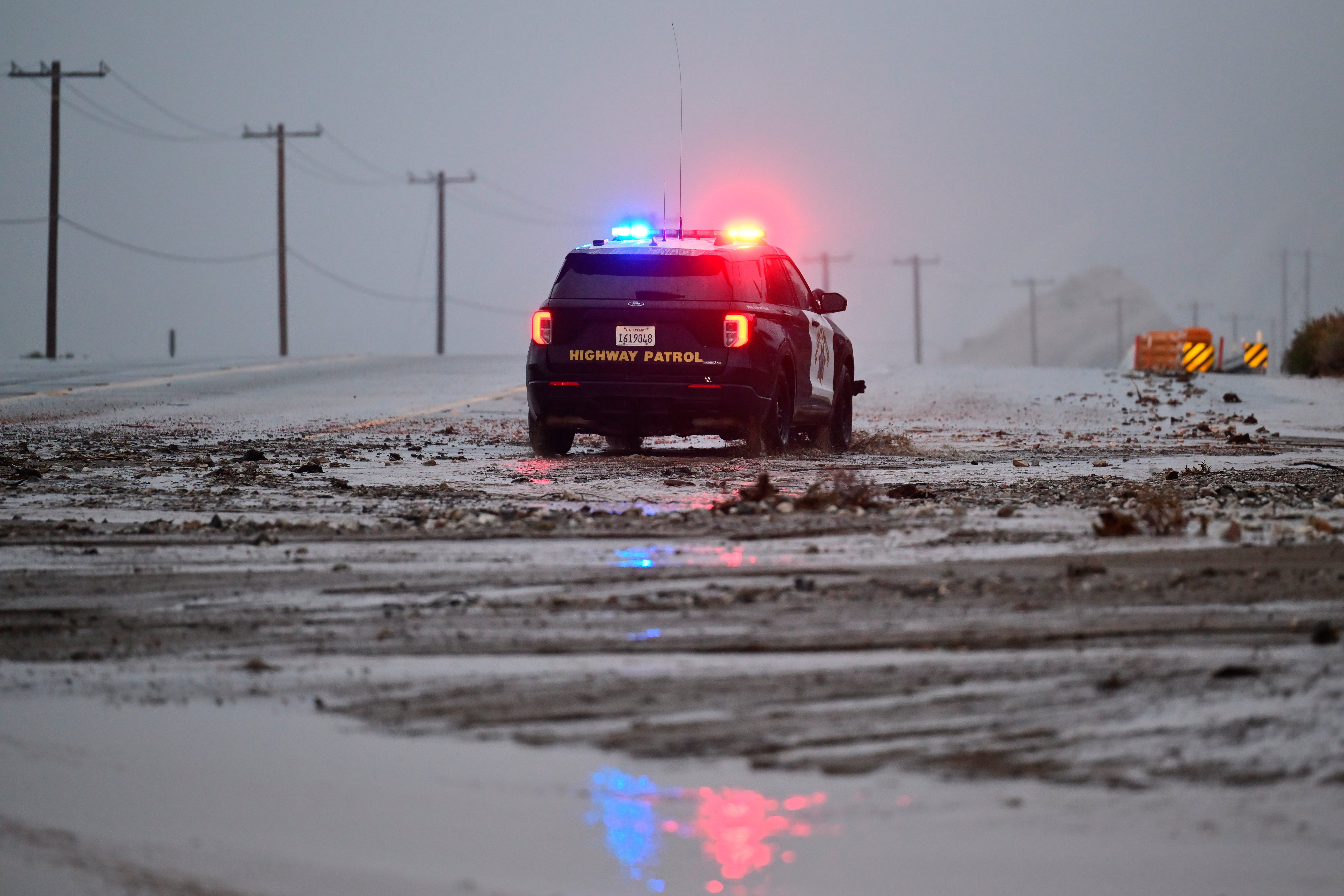 A police officer drives through flooded roads in Wrightwood, California after the area was pummeled by rain over Christmas Eve and Christmas Day