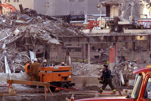 A New York firefighter walks through debris at Ground Zero where the twin towers used to stand (Paul Faith/PA)
