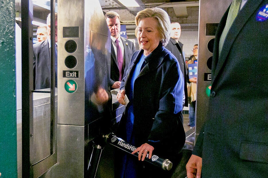 Democrat presidential candidate Hillary Clinton holds her MetroCard as she goes through the turnstile to enter the subway in the Bronx borough of New York, April 7, 2016. (AP Photo/Richard Drew, File)