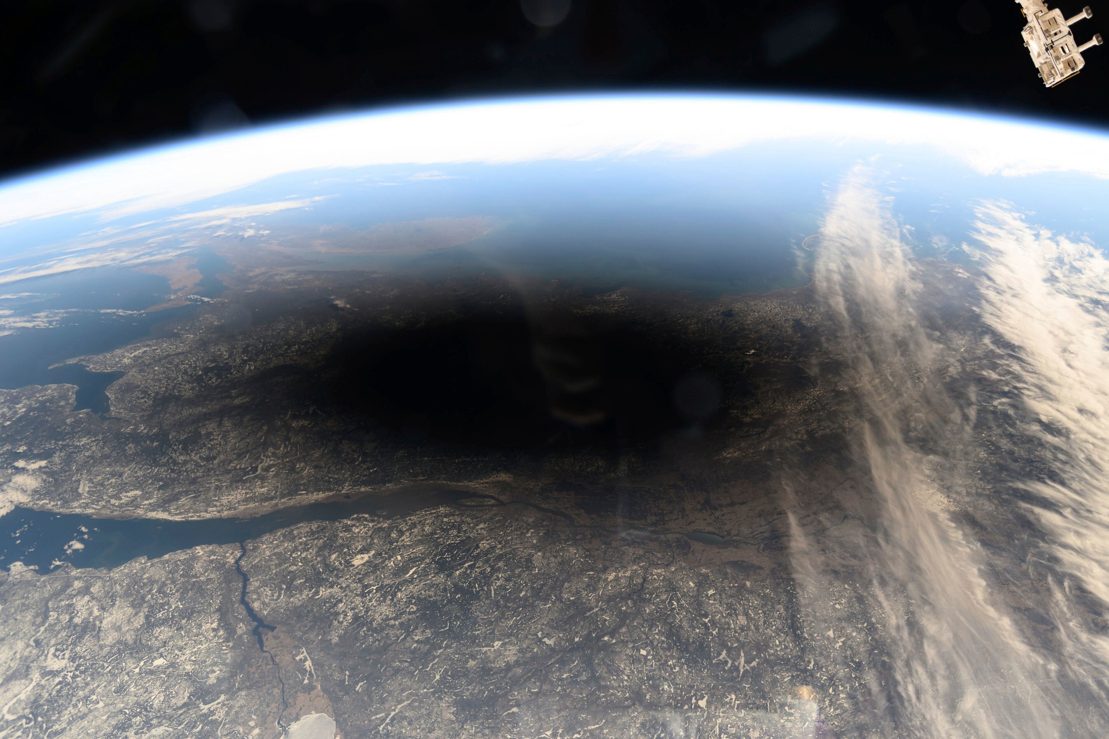 This photo provided by NASA shows the Moon's shadow covering portions of Canada and the U.S. during a total solar eclipse as seen from the International Space Station on Monday, Aug. 8, 2024. (NASA via AP, File)