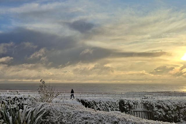 The sun rises over the snowy conditions on the East Yorkshire coast, near Skipsea (Amy Crowther/PA)