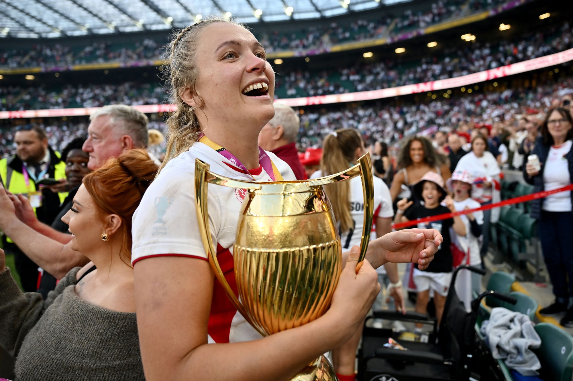 <p>Zoe Stratford of England takes the Women's Rugby World Cup Trophy to her family in the stands</p>