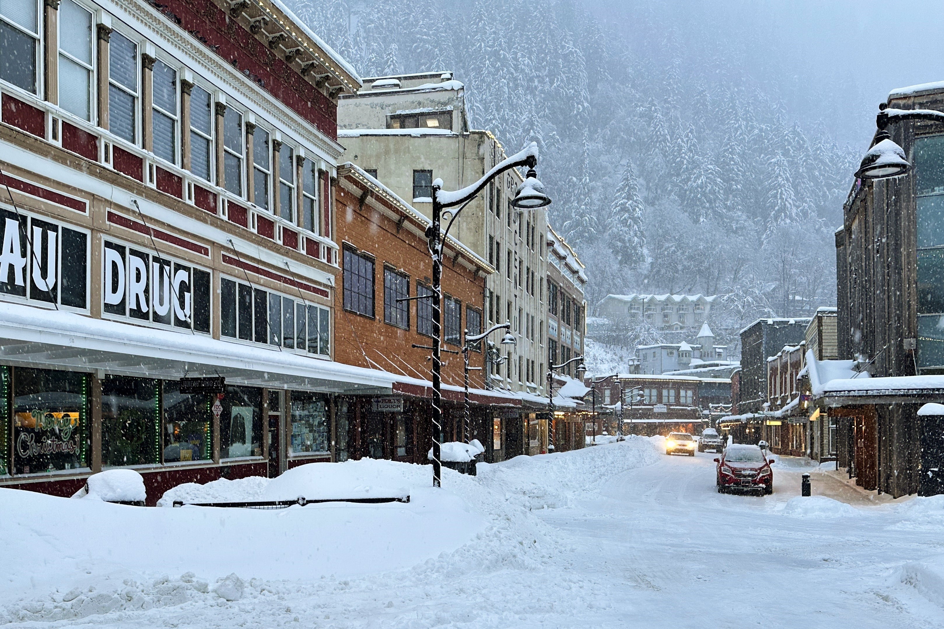 A car drives down a snowy main street in downtown Juneau, Alaska, Monday, Dec. 29, 2025