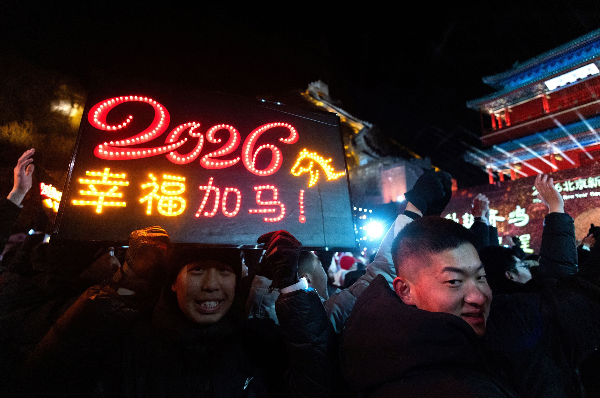 A man holds a board with the digits 2026 and a depiction of a horse, the symbol of the upcoming year, during a new ear countdown ceremony at the Juyongguan section of the Great Wall, also known as Juyong Pass, in Beijing, China.