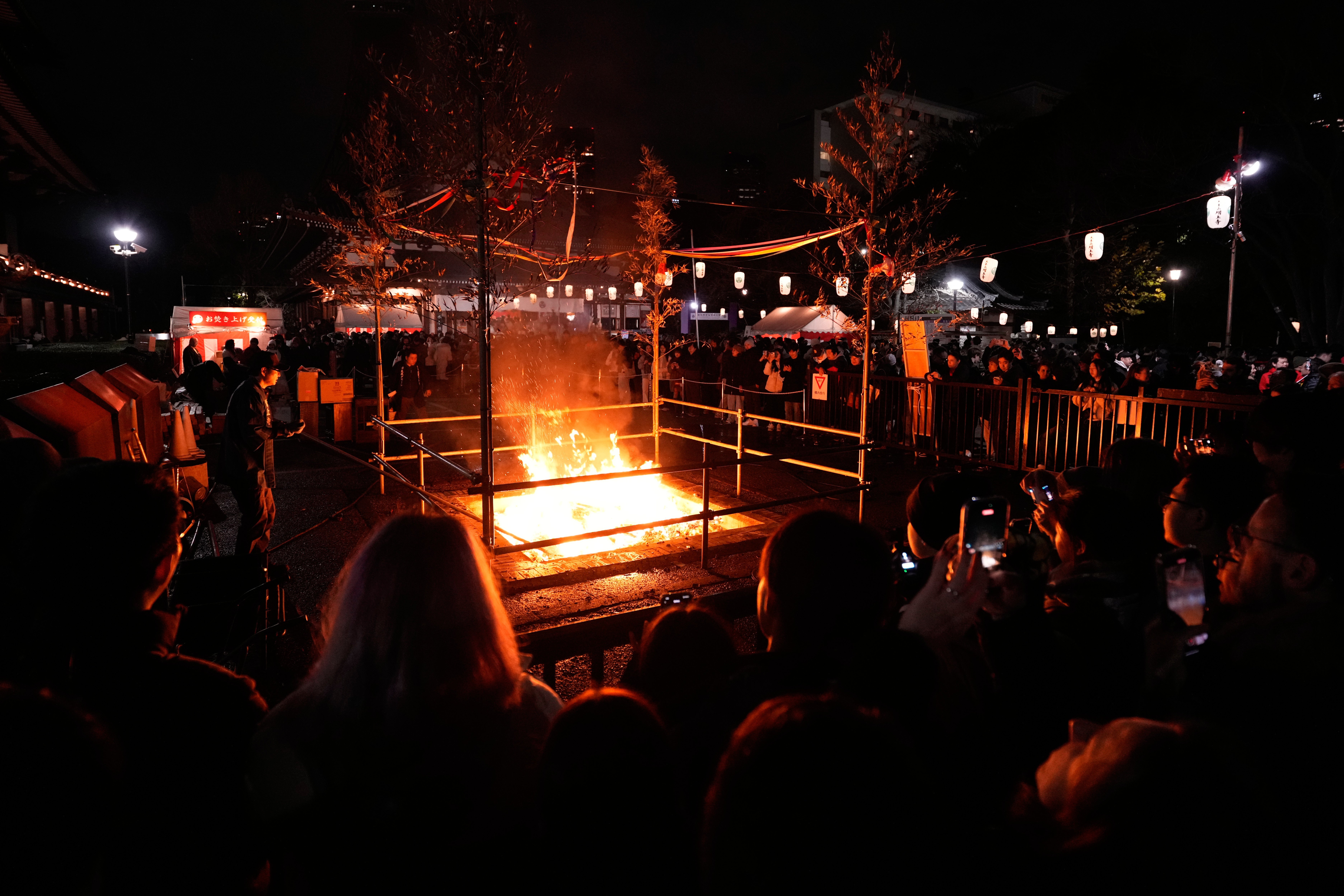 People burn old resolutions on the New Year at the Zojoji Buddhist temple, minutes after midnight Thursday Jan. 1, 2026, in Tokyo