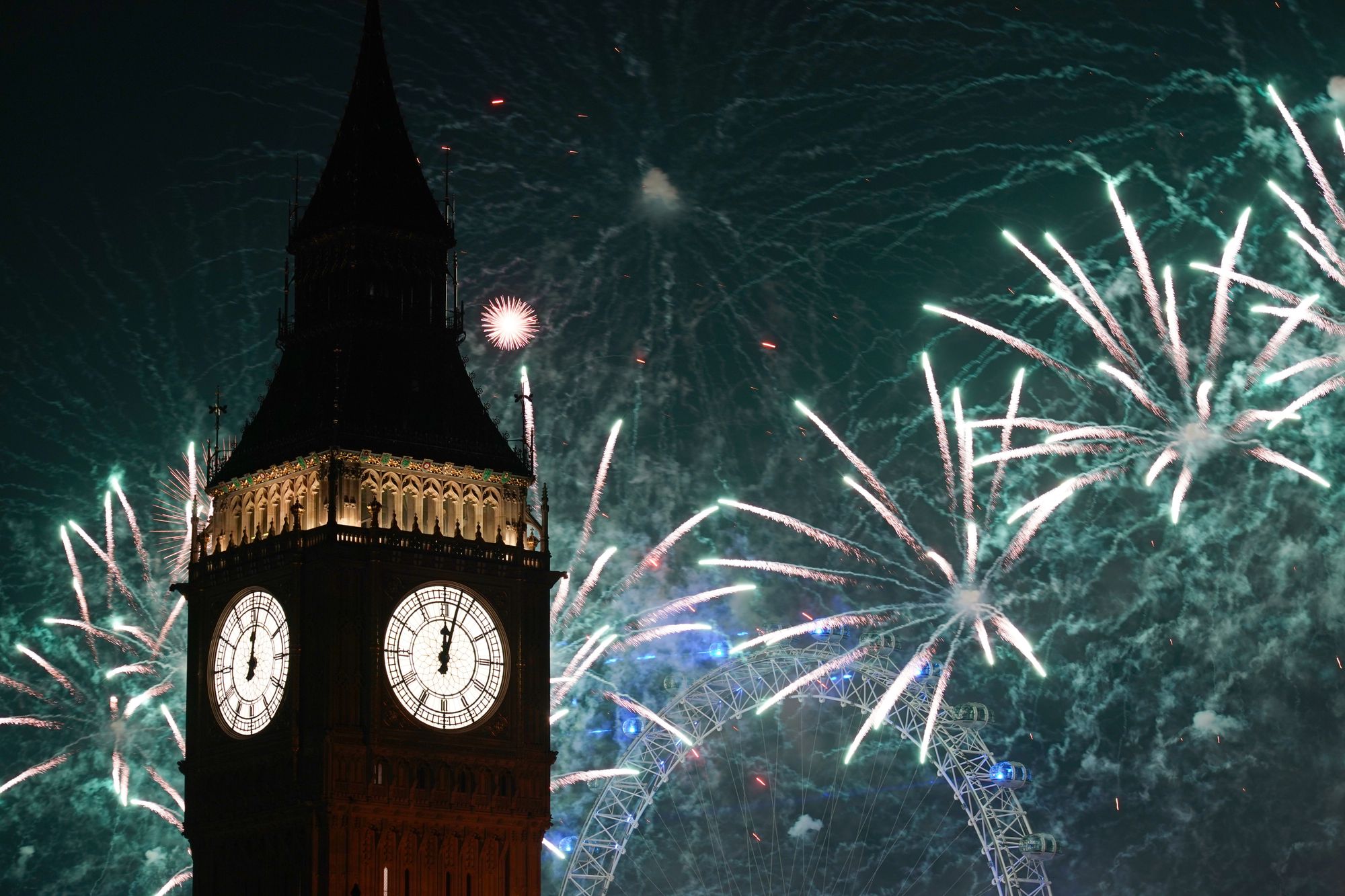Fireworks light up the sky over Elizabeth Tower and the London Eye in central London during the New Year celebrations