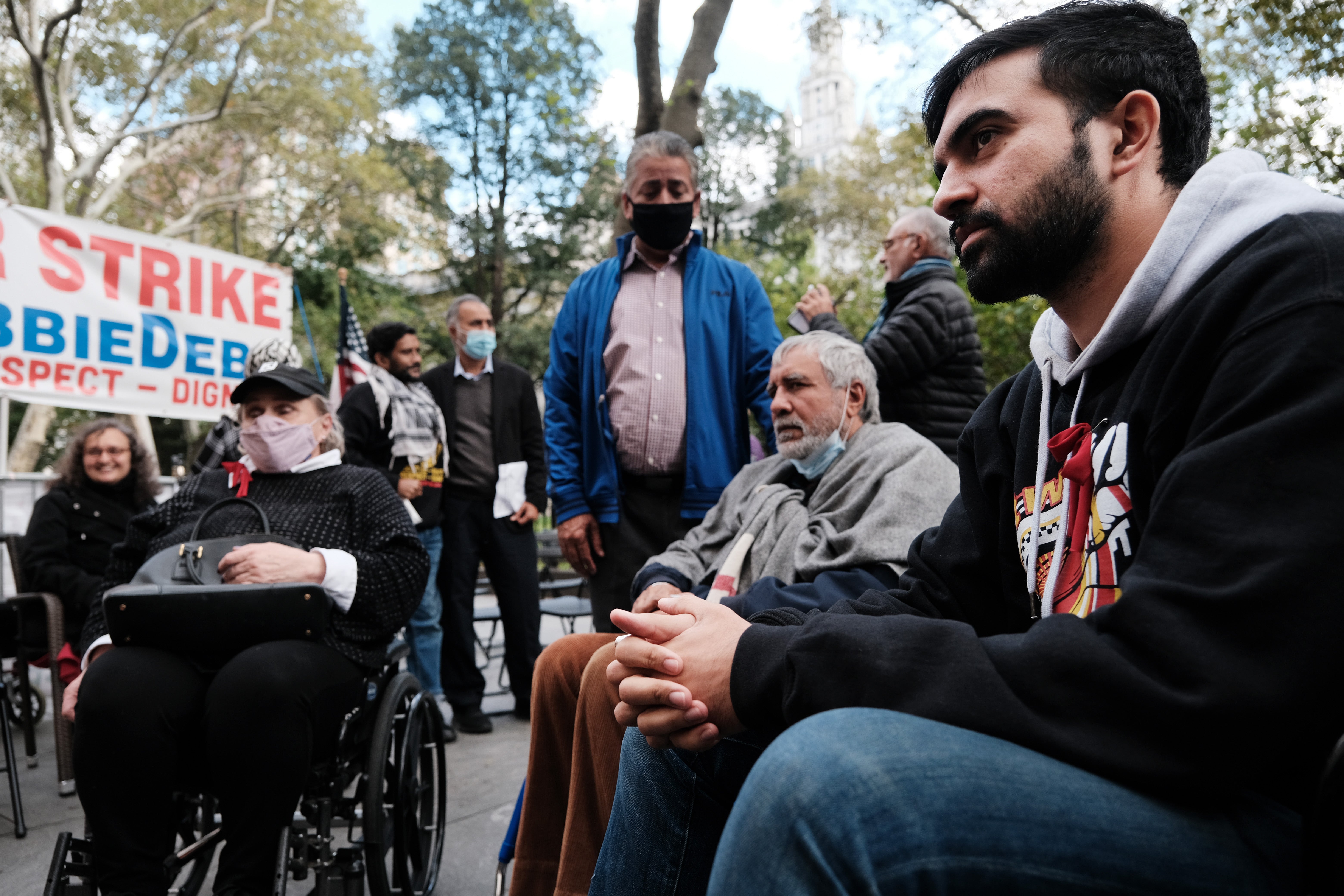 Mamdani (pictured right) sits with fellow hunger strikers in 2021