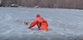 Watch firefighter crawl across frozen pond to rescue dog