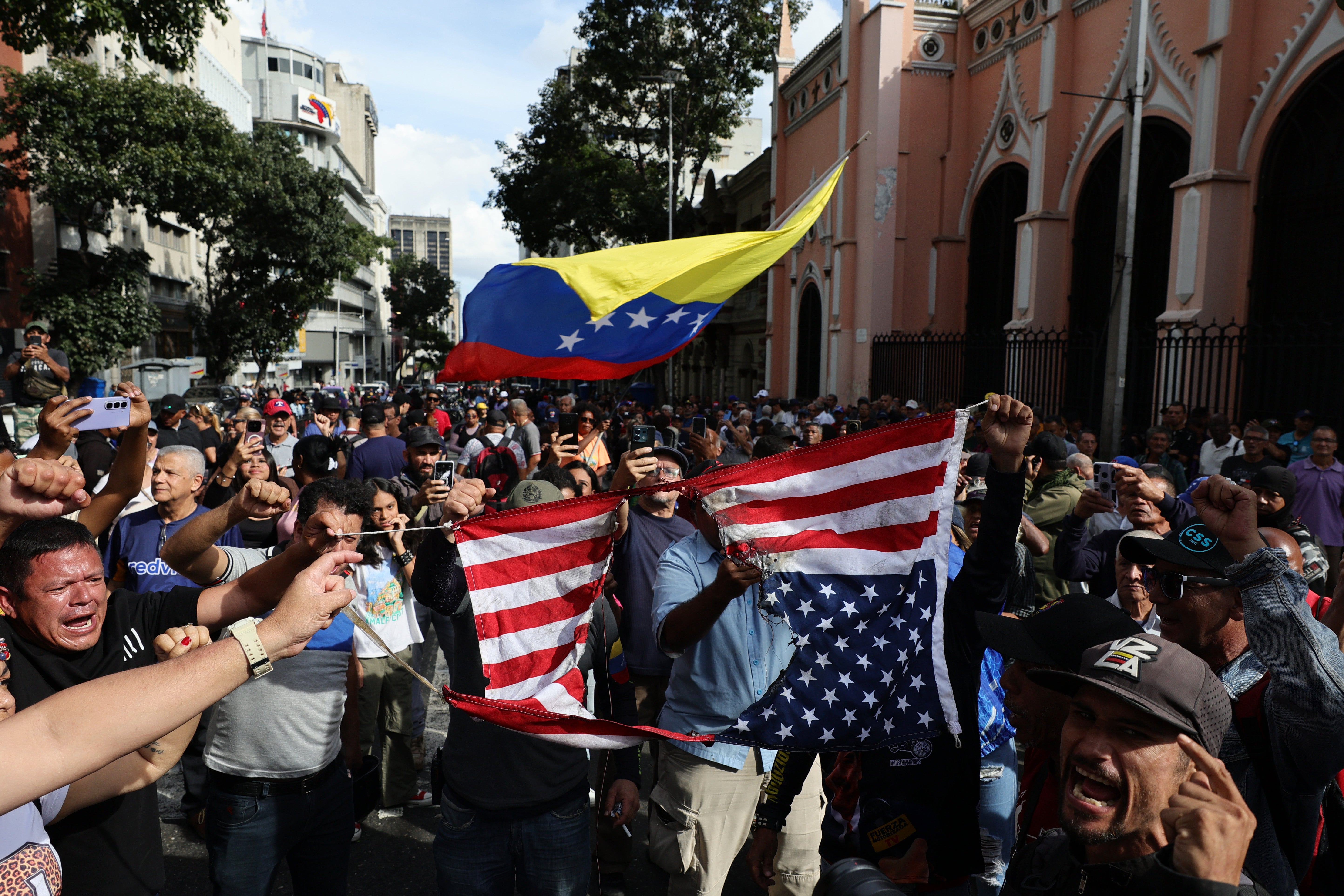 <p> Supporters of Nicolas Maduro burn a United States flag during a gathering near Miraflores palace</p>