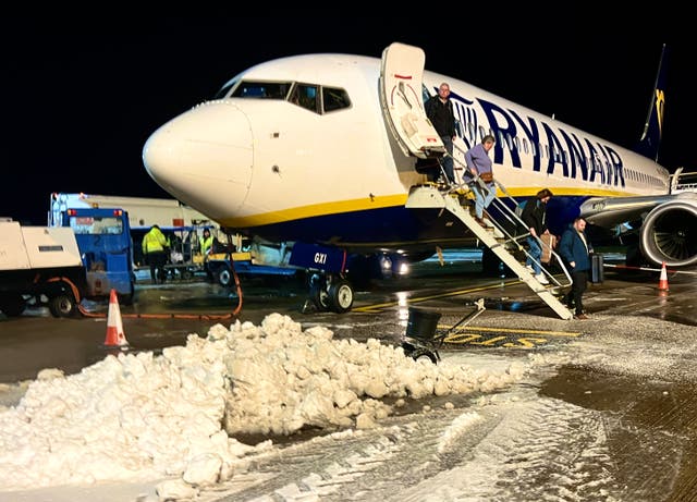 <p>Freeze frame: Ryanair passengers from Alicante arriving at a snow-covered Norwich airport</p>