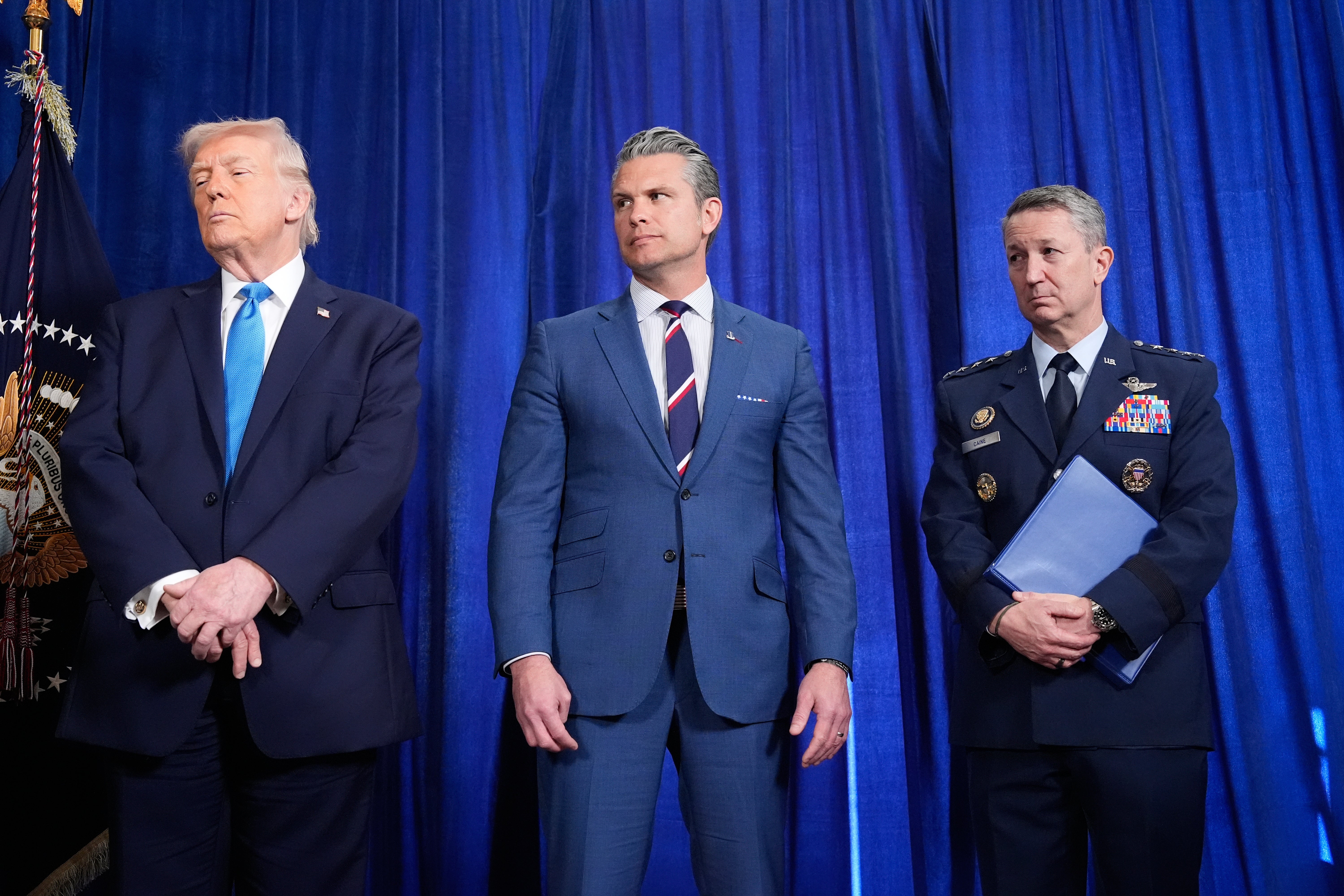 Donald Trump, Pete Hegseth and Dan Caine pictured at a news conference at Mar-a-Lago on Saturday