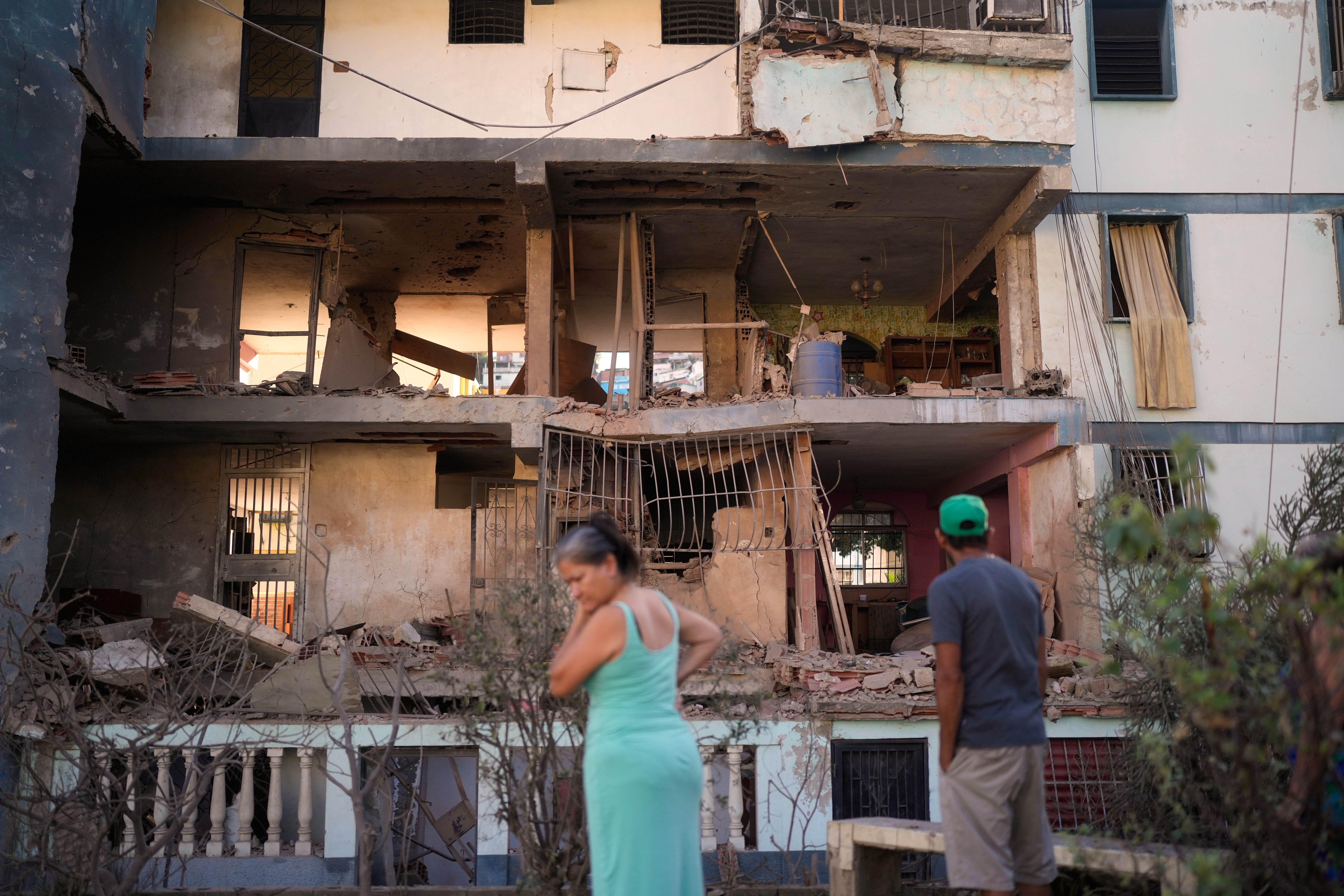 <p>Residents look at a damaged apartment complex that neighbors say was hit during U.S. strikes to capture Venezuelan President Nicolás Maduro</p>