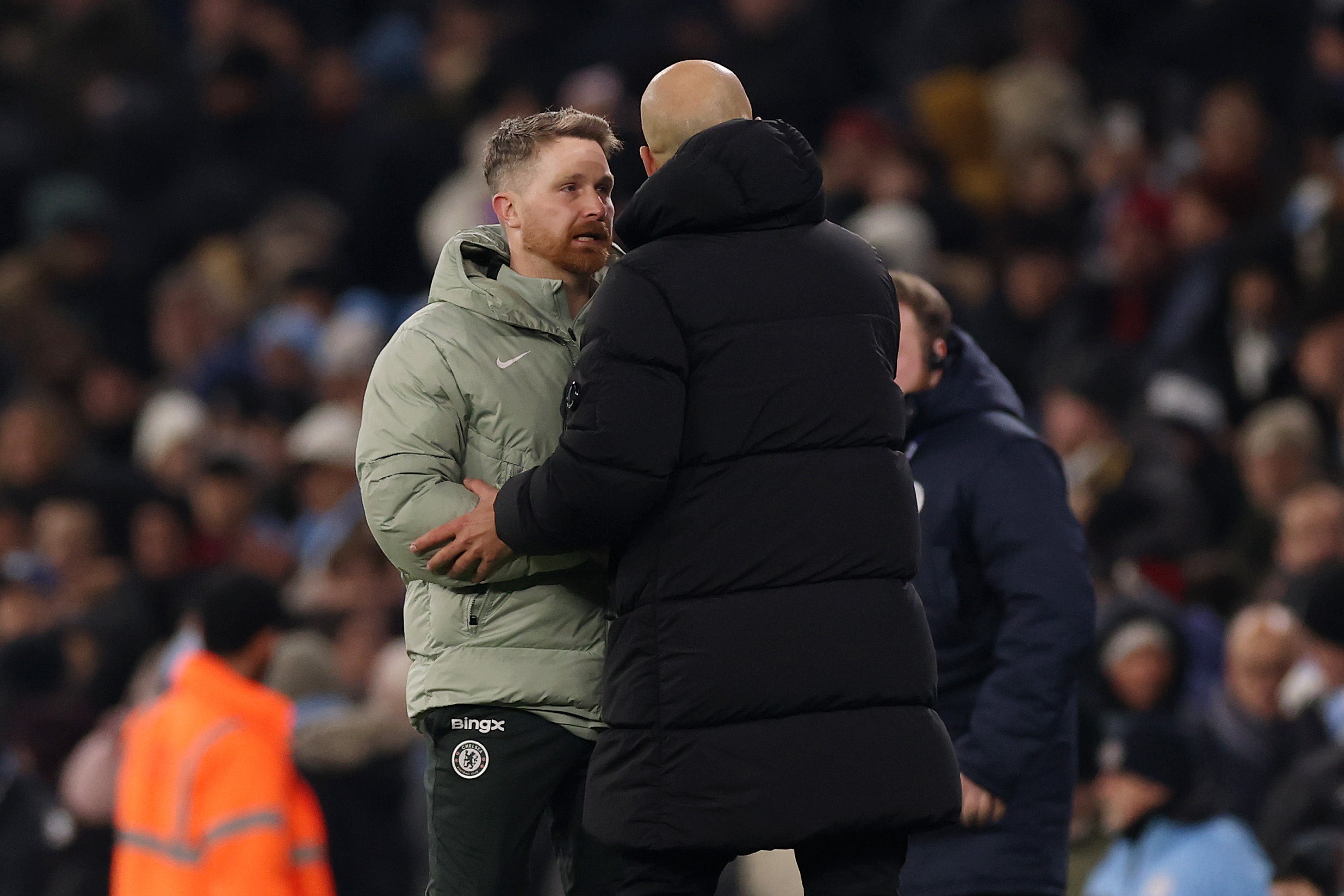 Calum McFarlane, Interim Manager of Chelsea, and Pep Guardiola, Manager of Manchester City, shake hands