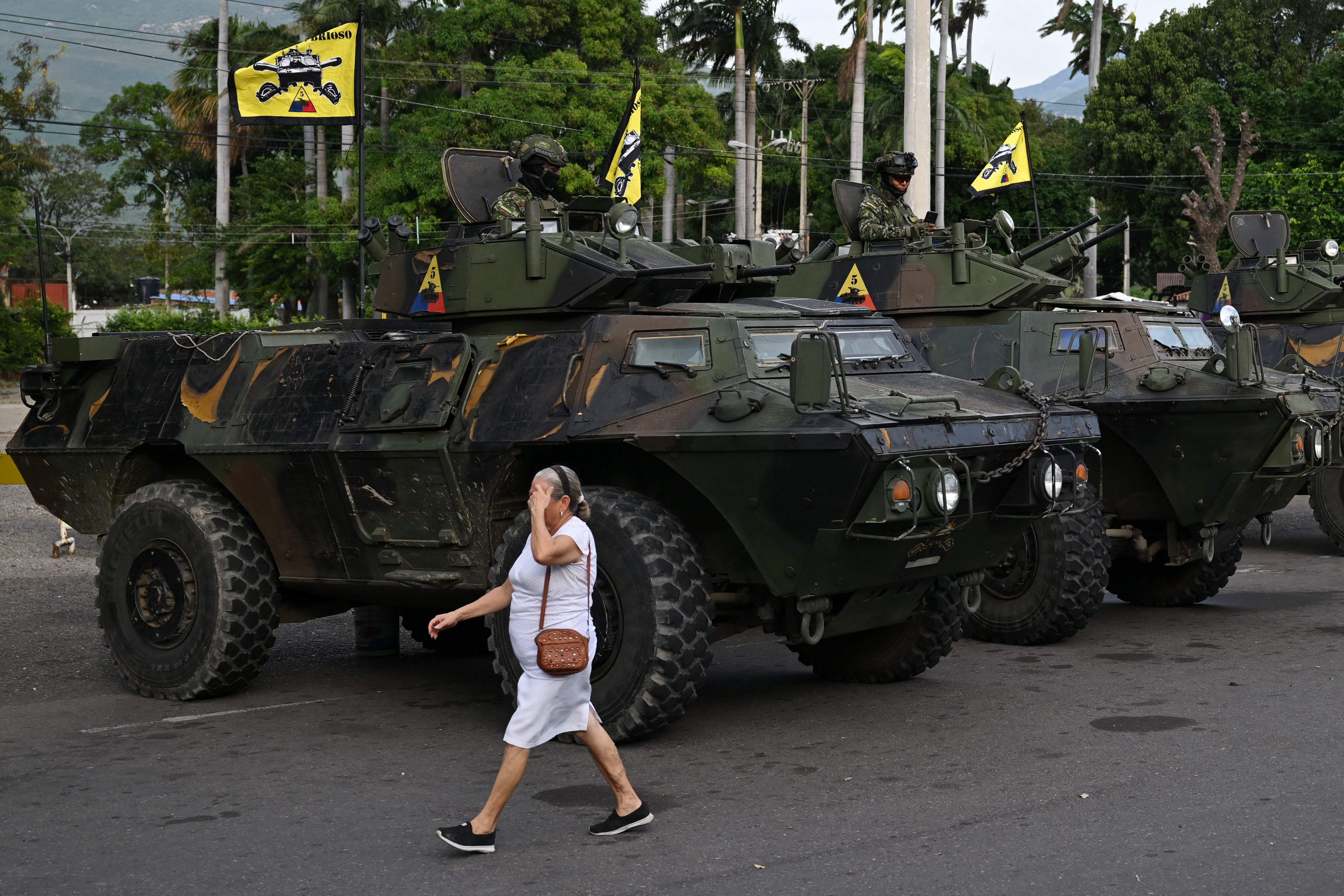 <p>A woman walks past military vehicles at the border crossing with Venezuela in Cucuta </p>