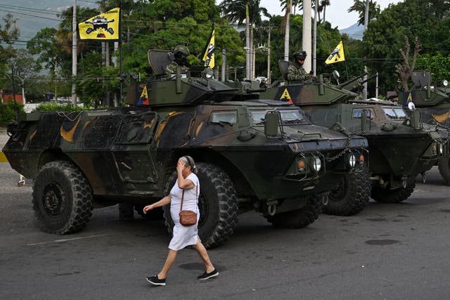 <p>A woman walks past military vehicles at the border crossing with Venezuela in Cucuta, Colombia, on 3 January 2026, after US forces captured Venezuela's President Nicolas Maduro</p>