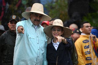 Venezuela's President Nicolas Maduro gestures next to his wife, First Lady Cilia Flores, during a rally to mark the anniversary of the Battle of Santa Ines, in Caracas on 10 December 2025