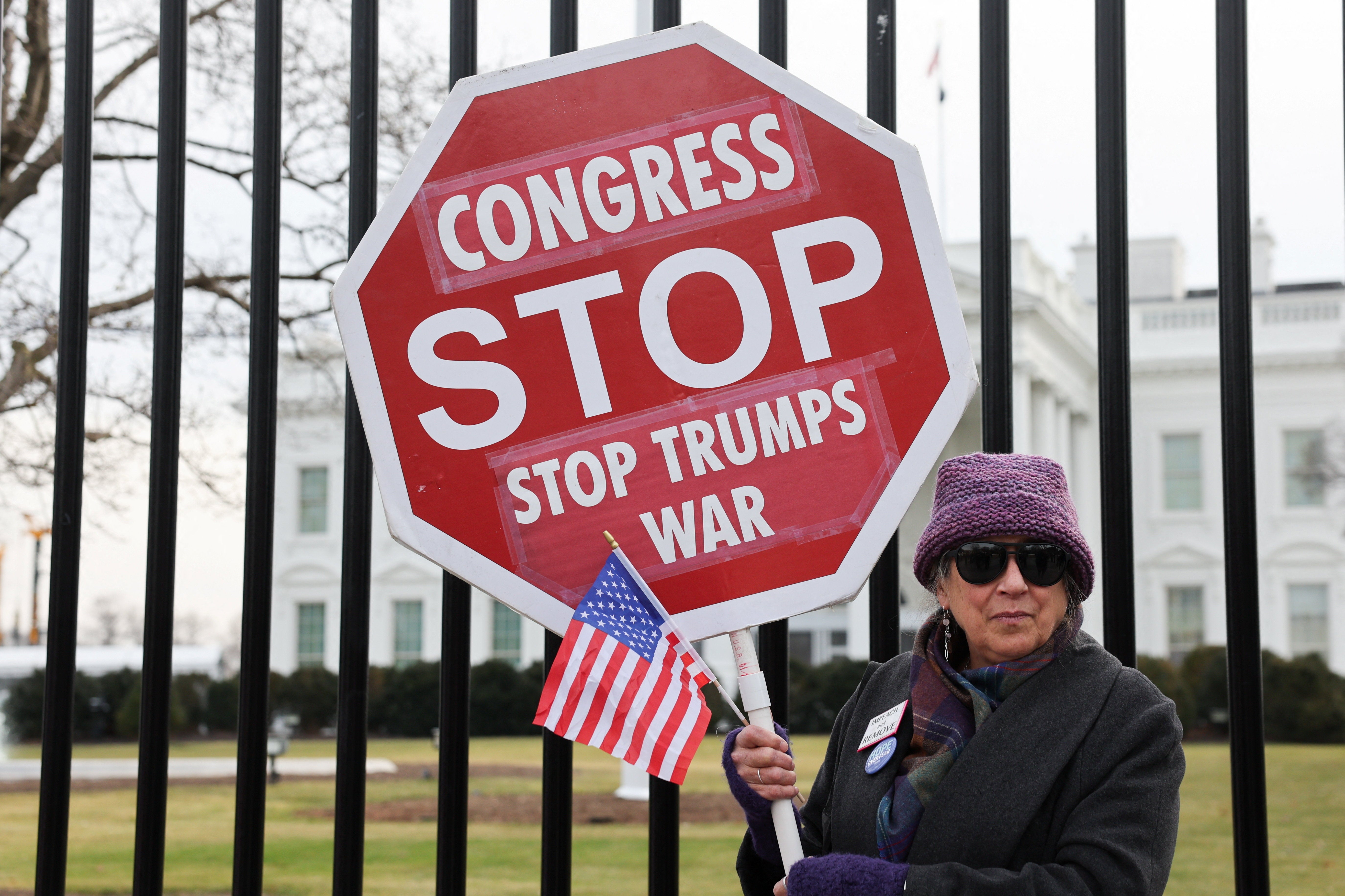 <p>A demonstrator holds a sign against U.S. military action in Venezuela, at Lafayette Square in front of the White House </p>