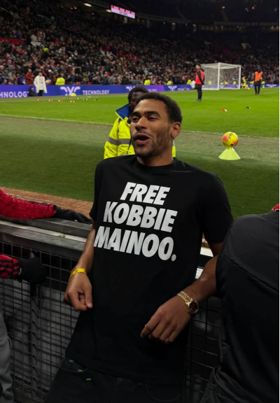 Mainoo's half-brother, Jordan Mainoo-Hames, wearing a 'Free Kobbie Mainoo' shirt at Old Trafford