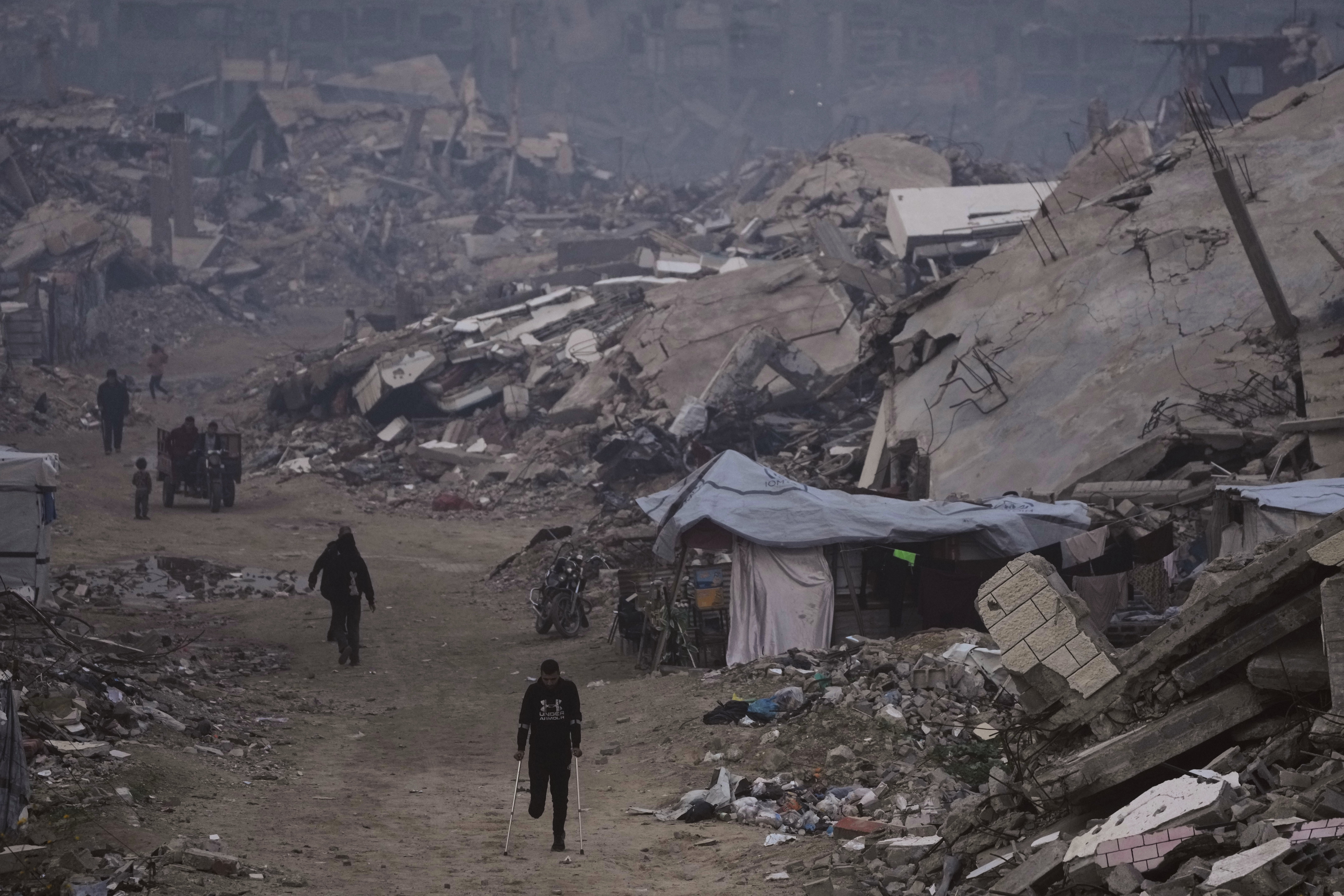 <p>Palestinians walk through the ruins of Gaza City on 4 January 2026</p>