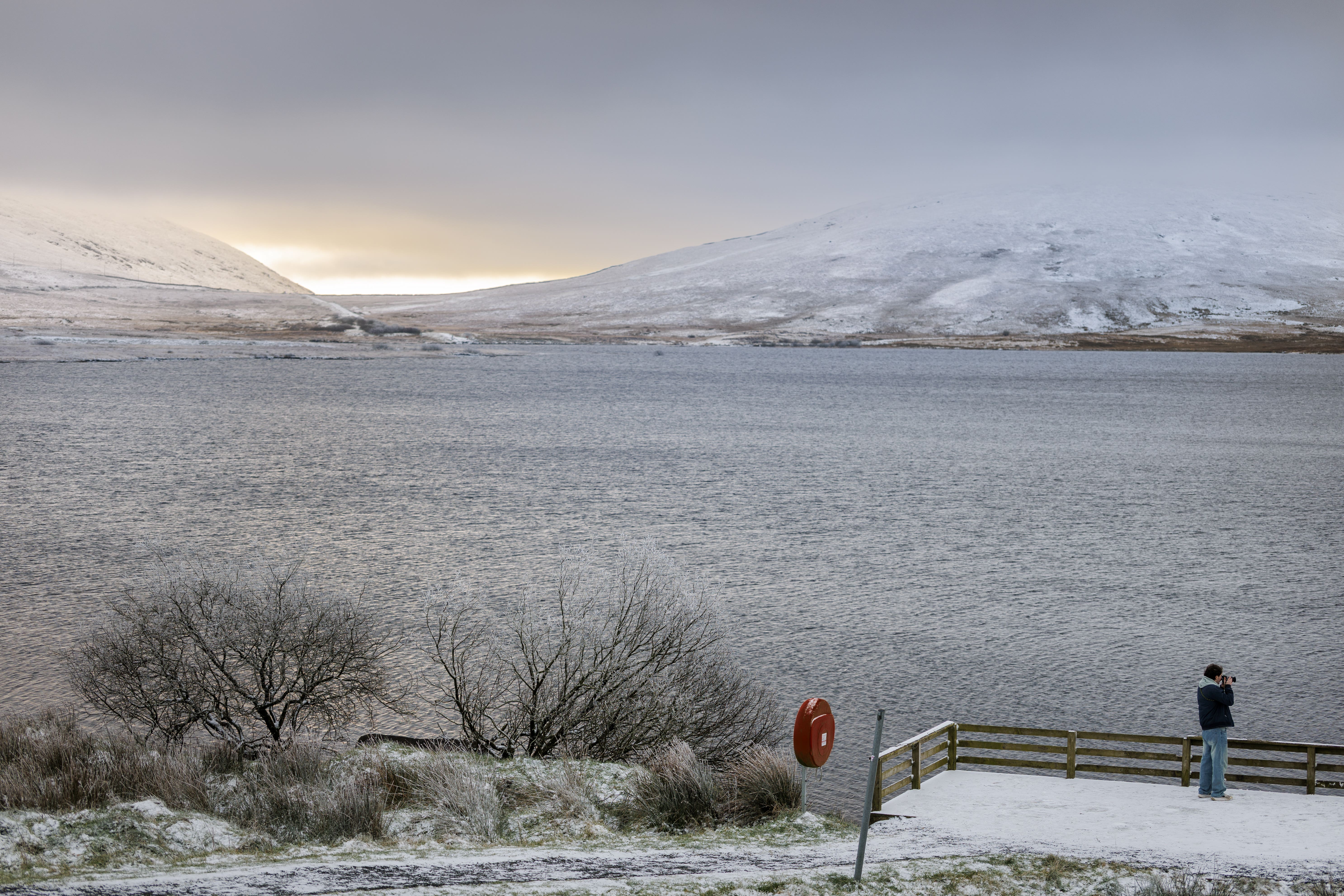 A person takes pictures at the Spelga Dam in the Mourne Mountains, County Down, Northern Ireland (Liam McBurney/PA)
