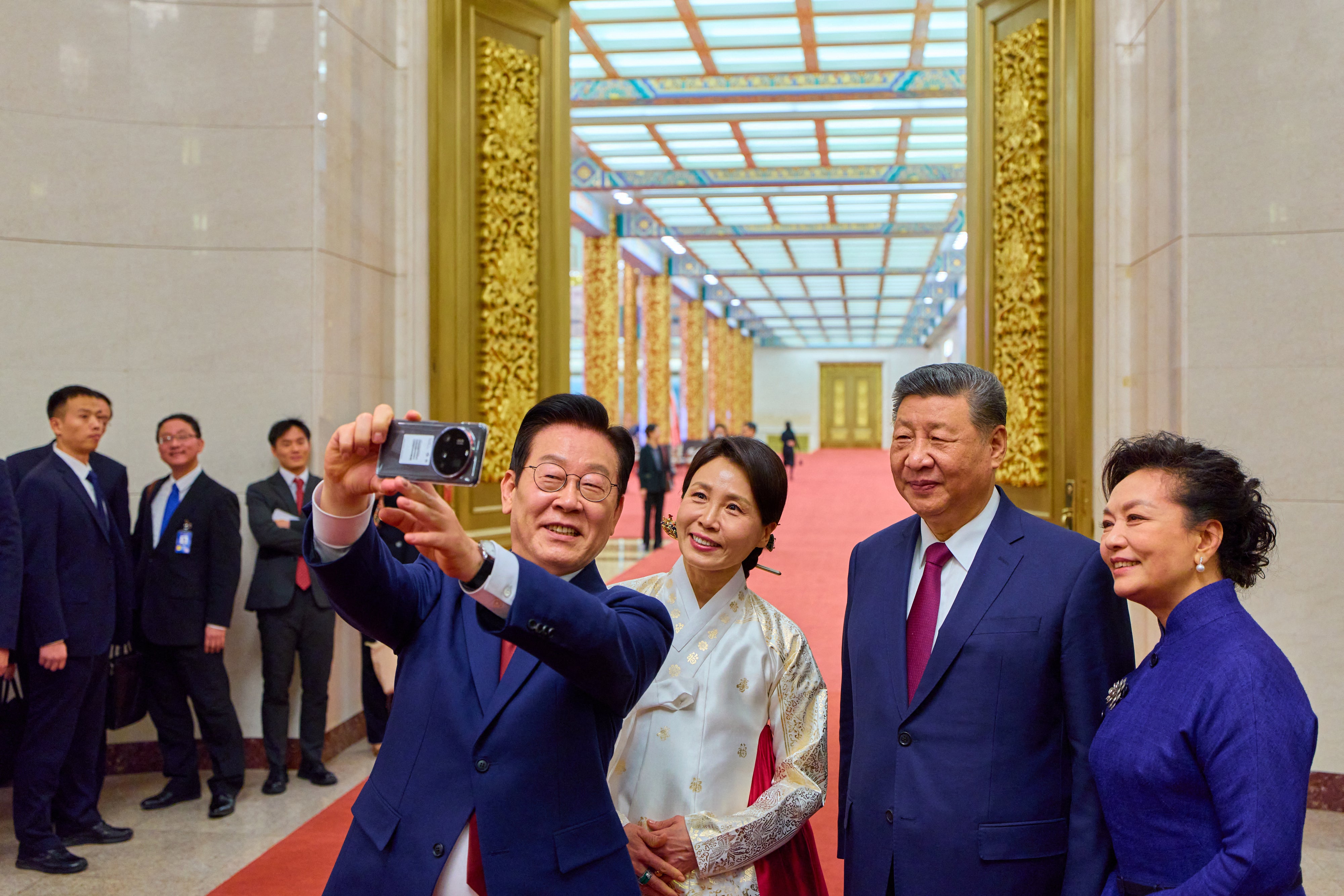 <p>South Korea's President Lee Jae Myung (L) and his wife Kim Hea Kyung (2nd L) take a selfie with China's President Xi Jinping (2nd R) and his wife Peng Liyuan (R) after a dinner at the Great Hall of the People in Beijing </p>