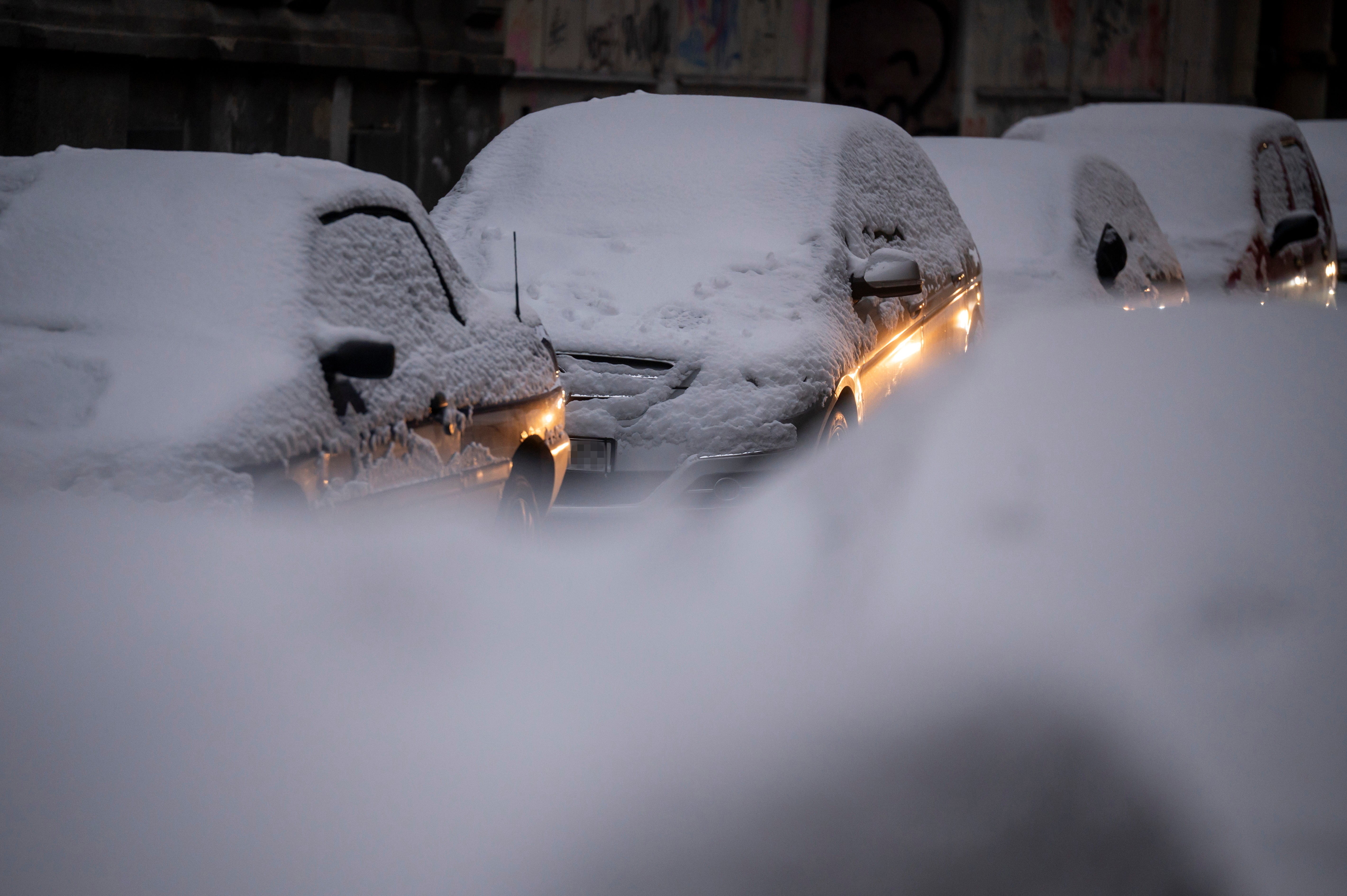 <p>Snow-covered cars are parked in a street in Budapest, Hungary</p>