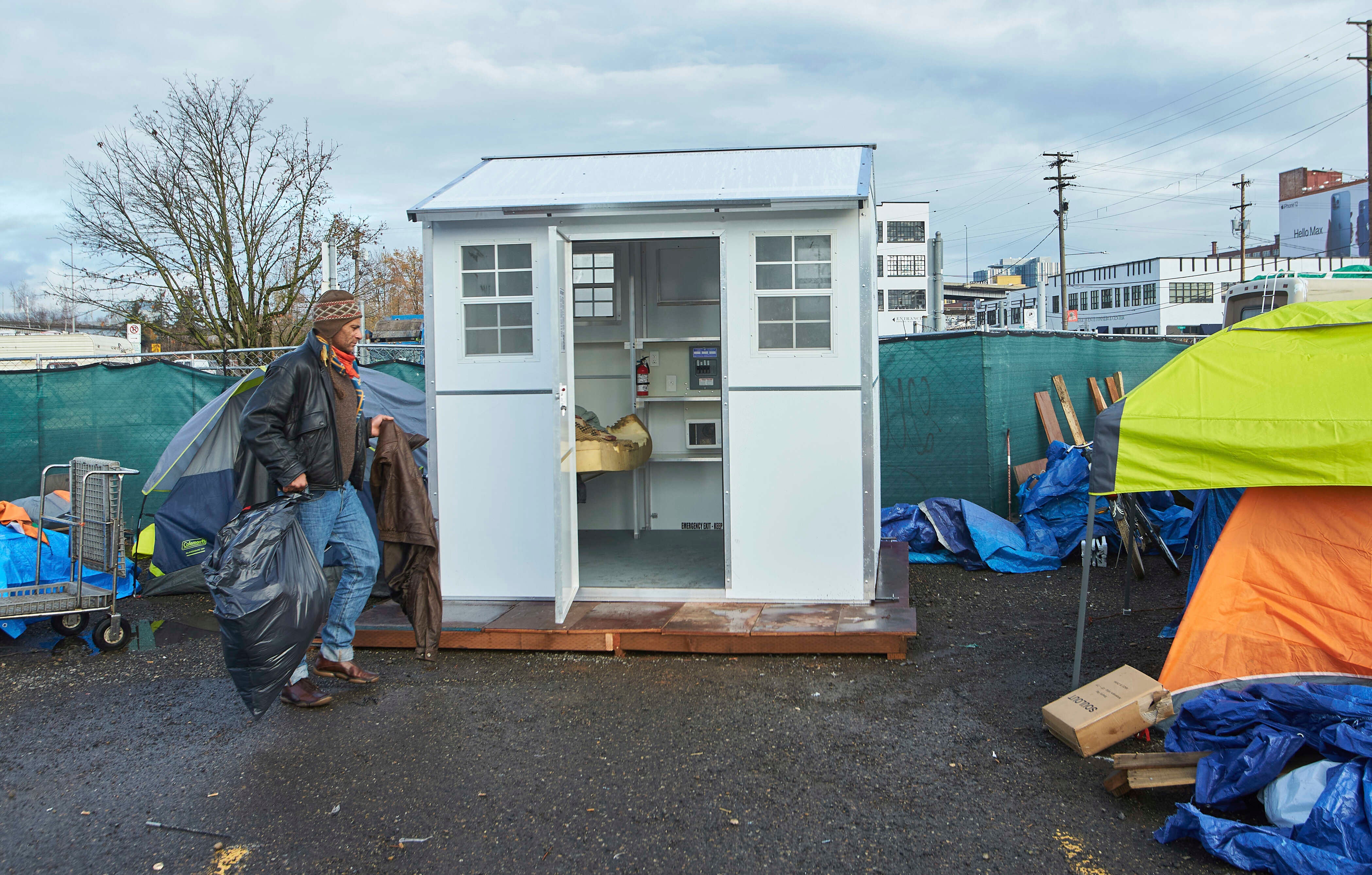 A man moves his belongings into a pod setup by the city in Portland, Oregon