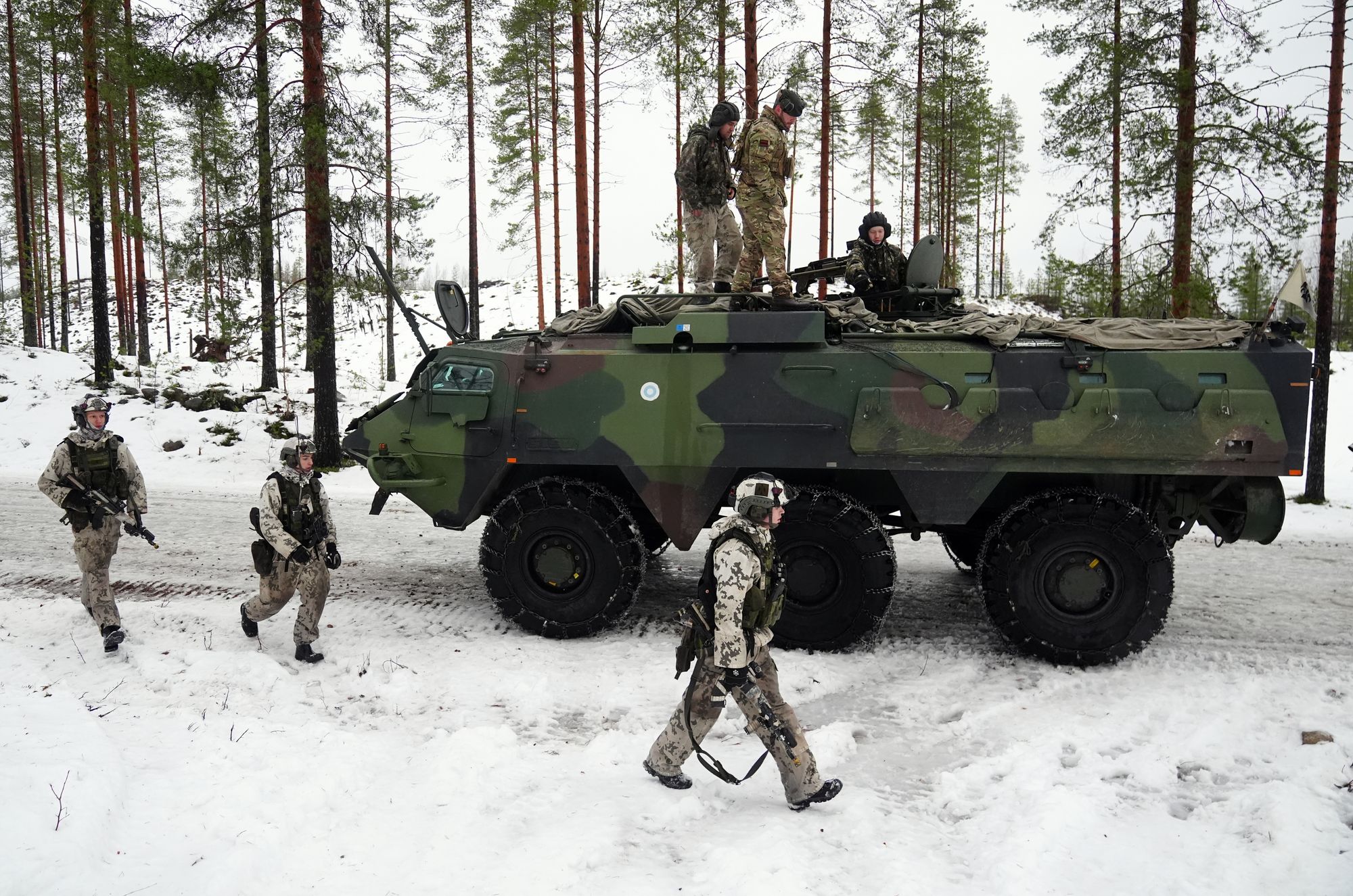 Members of the Finnish army and British army in a Patria Pasi armoured vehicle, on NATO's border with Russia