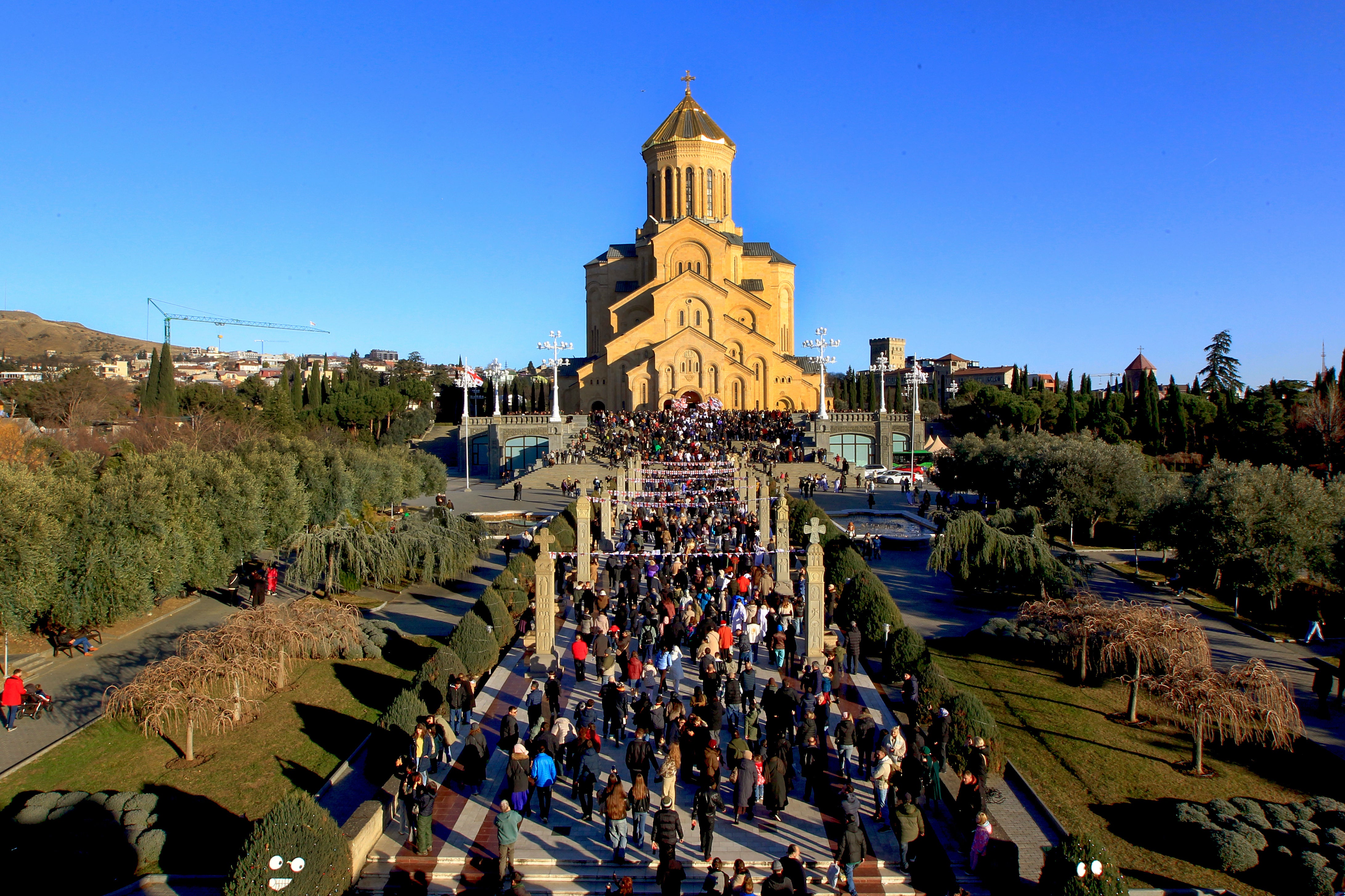 Georgians with national flags take part in a religious procession to the Holy Trinity Cathedral to mark Orthodox Christmas in Tbilisi