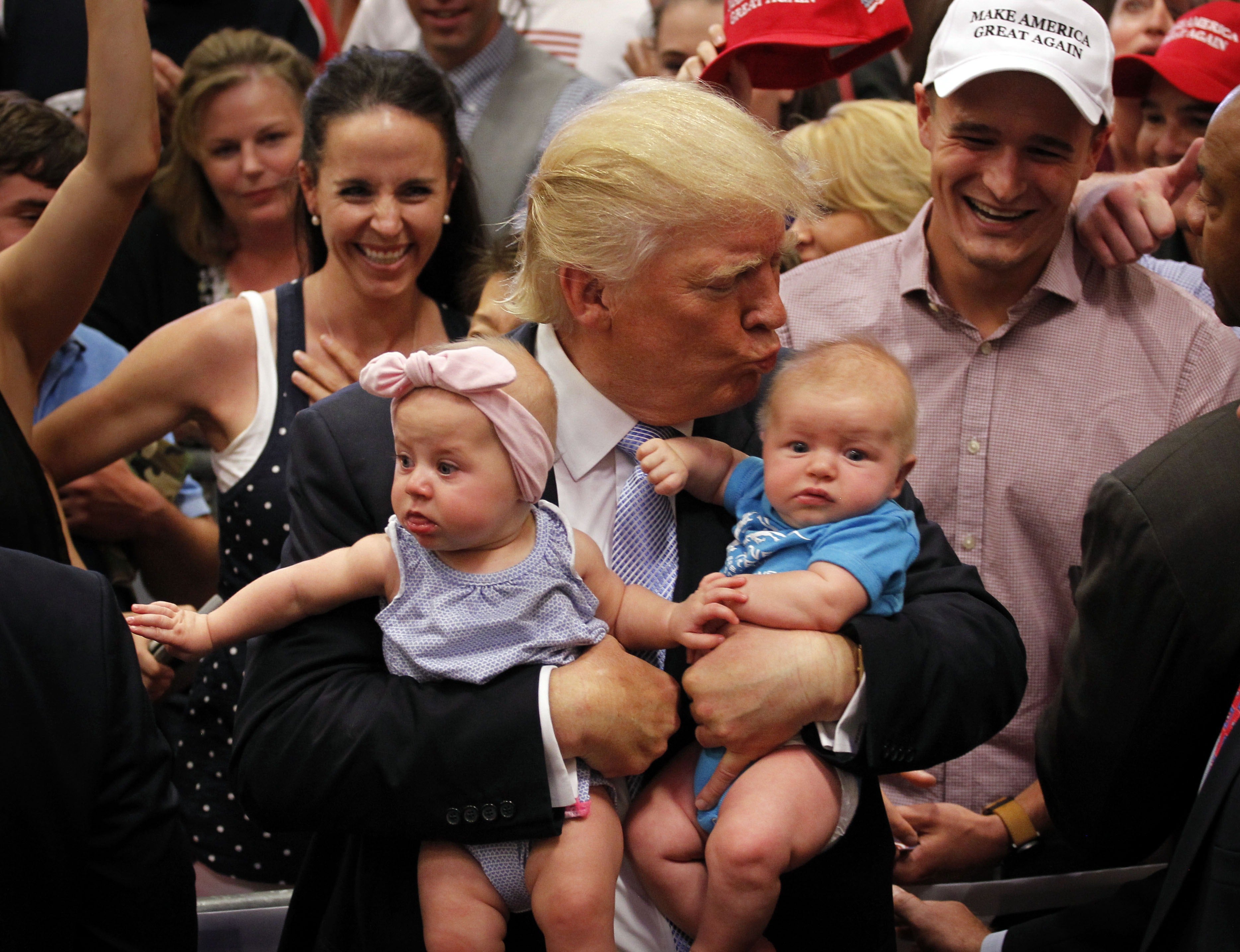Trump, pictured kissing a baby in 2016, has consistently pushed forward policies that the administration believes will encourage people to have more children