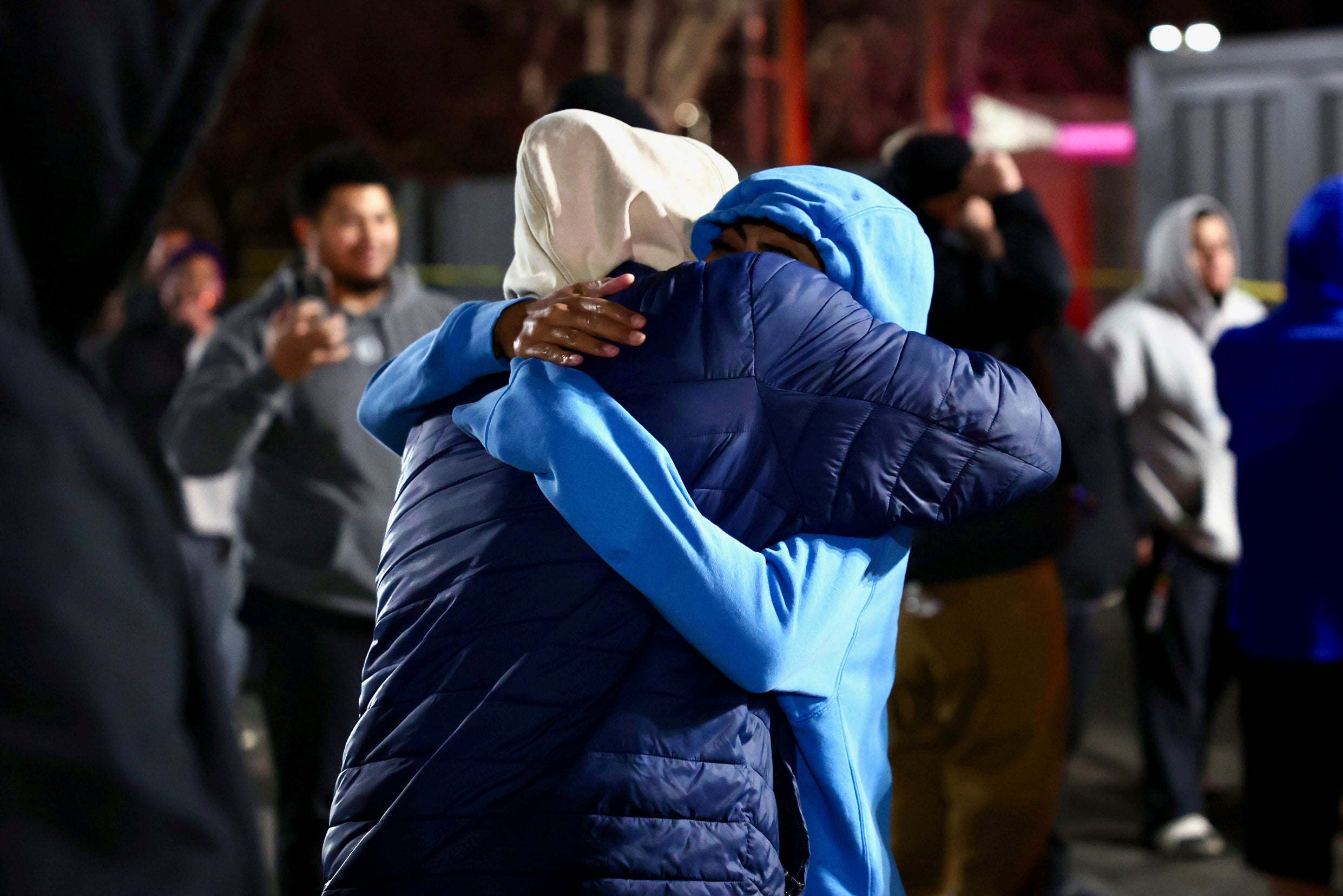 People hug each other after a fatal shooting in a parking lot of The Church of Jesus Christ of Latter-day Saints in Salt Lake City on Wednesday