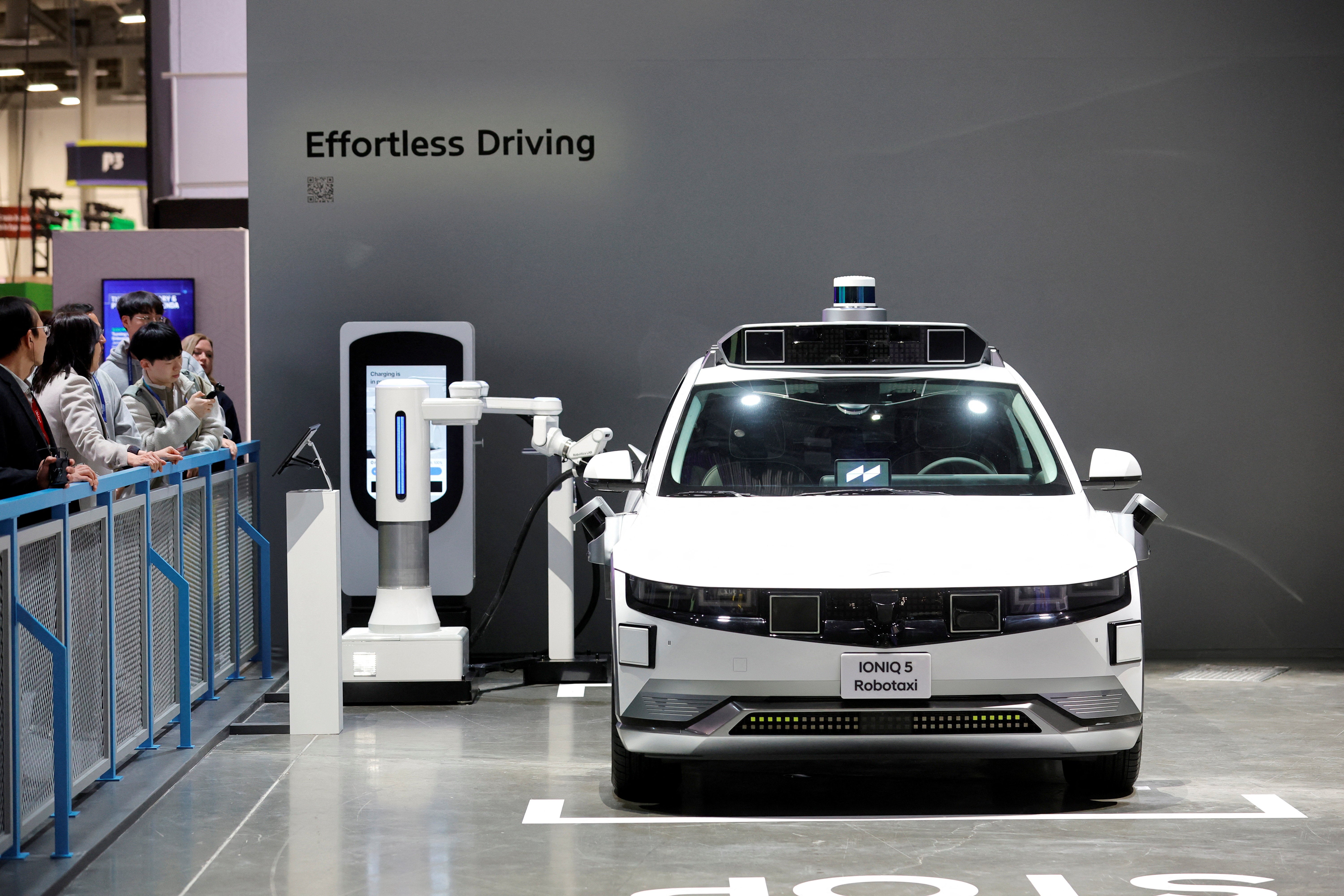 A Hyundai Ioniq 5 robotaxi, an electric, self-driving vehicle, is charged in the Hyundai Motor Group booth during CES 2026.