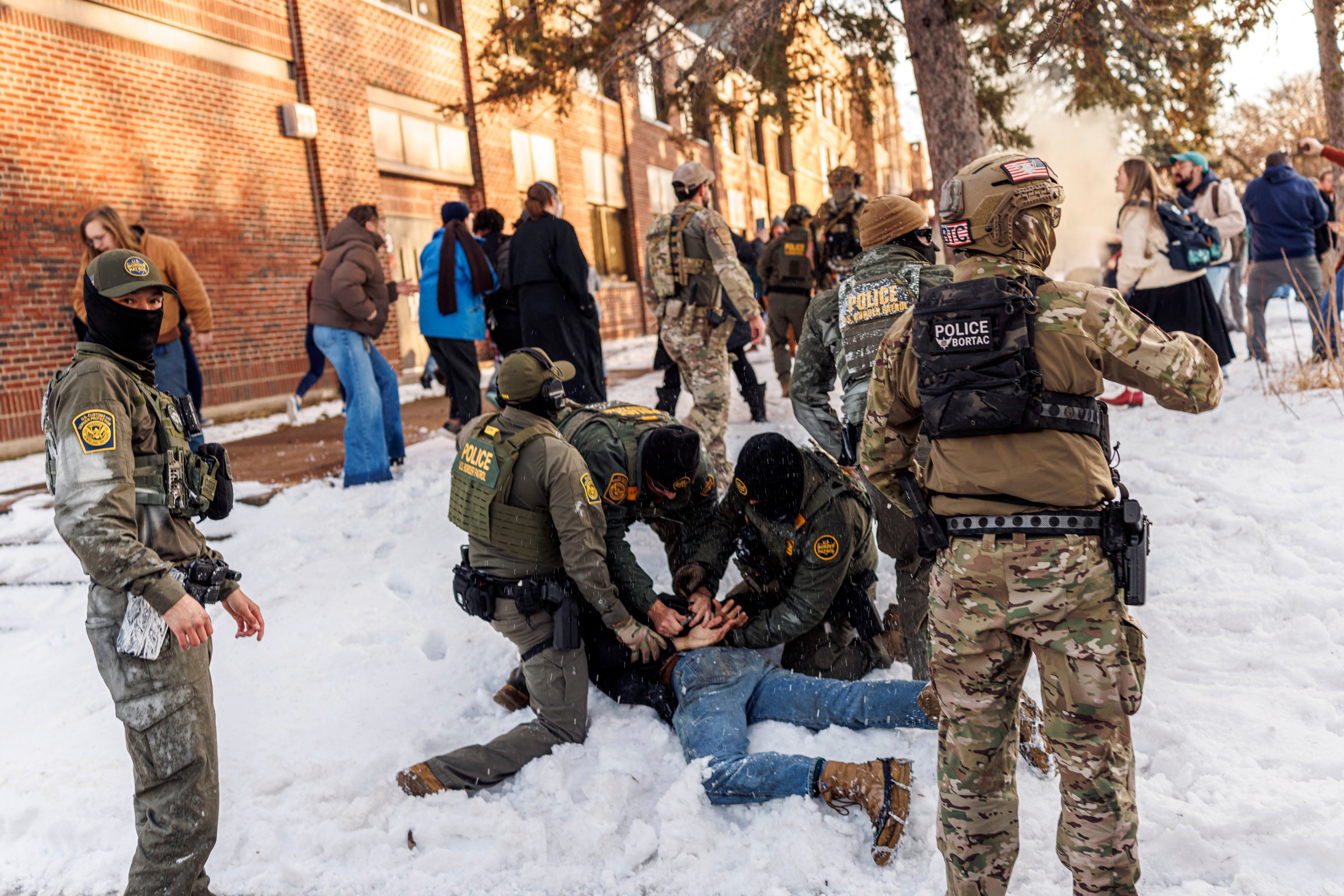 <p>Border Patrol agents detain a person near Roosevelt High School in Minneapolis on January 7 as part of the Trump administration’s ongoing mass immigration operation in the city</p>