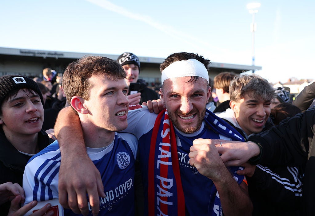 The bandaged Dawson, captain and scorer of Macclesfield’s first goal, celebrates with fans on the pitch