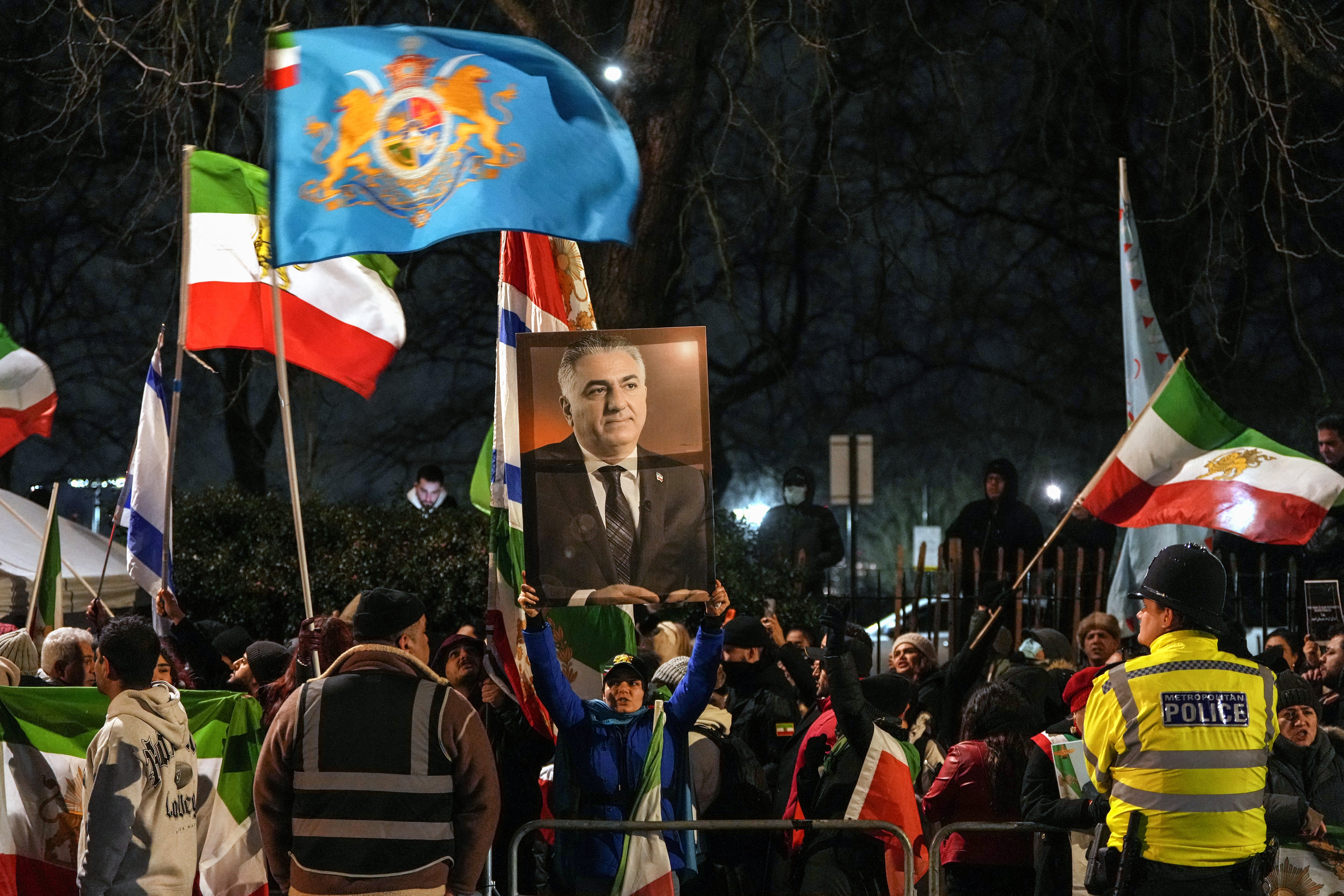 Anti-Iranian regime protesters hold up a portrait of Iranian opposition leader and son of the last shah of Iran Mohammad Reza Pahlavi, Reza Pahlavi (C), as they take part in a demonstration outside the Iranian Embassy in central London on January 10, 2026. (Photo by CARLOS JASSO / AFP via Getty Images)
