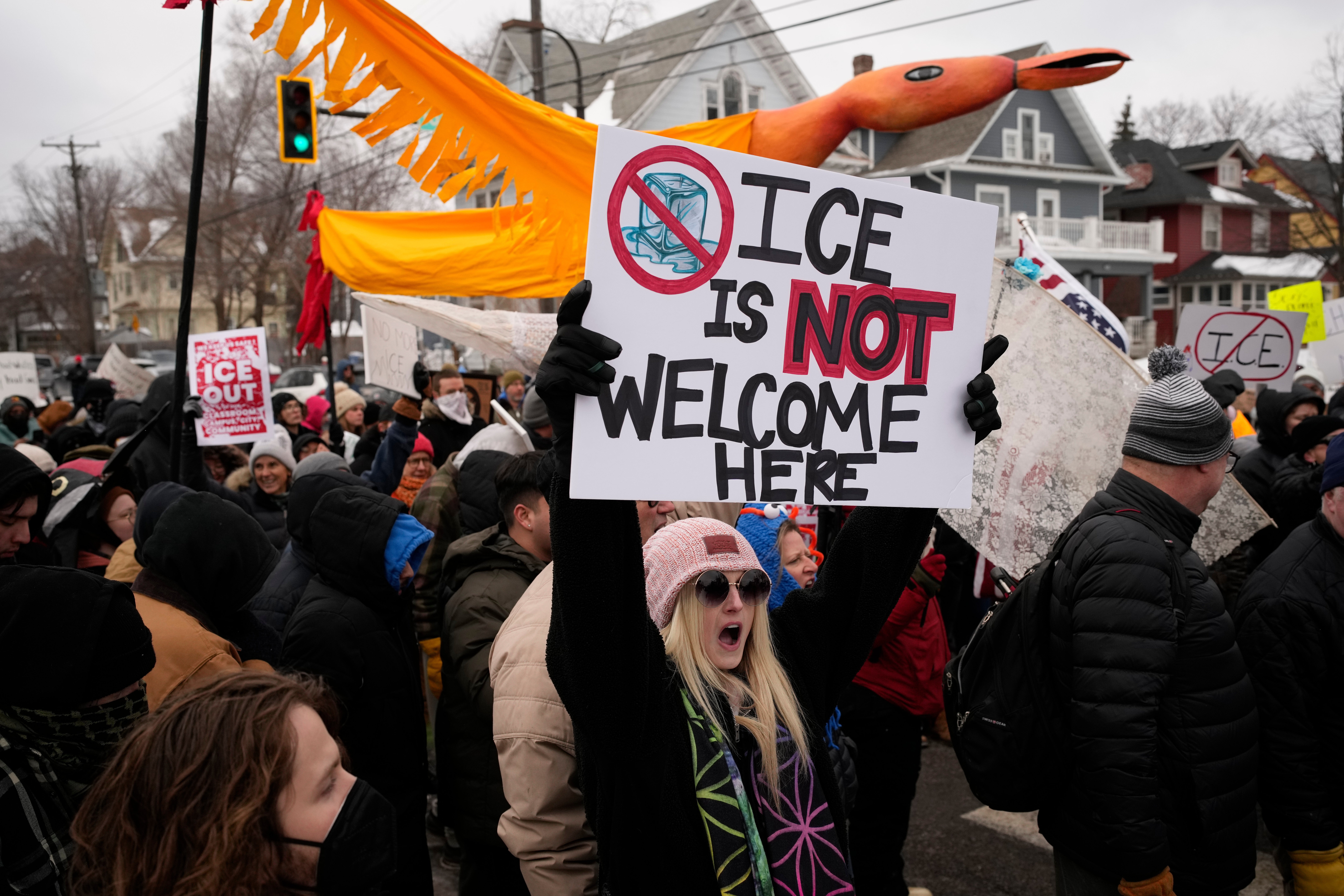 A protester in Minneapolis holds a sign claiming 'ICE is not welcome here' Saturday