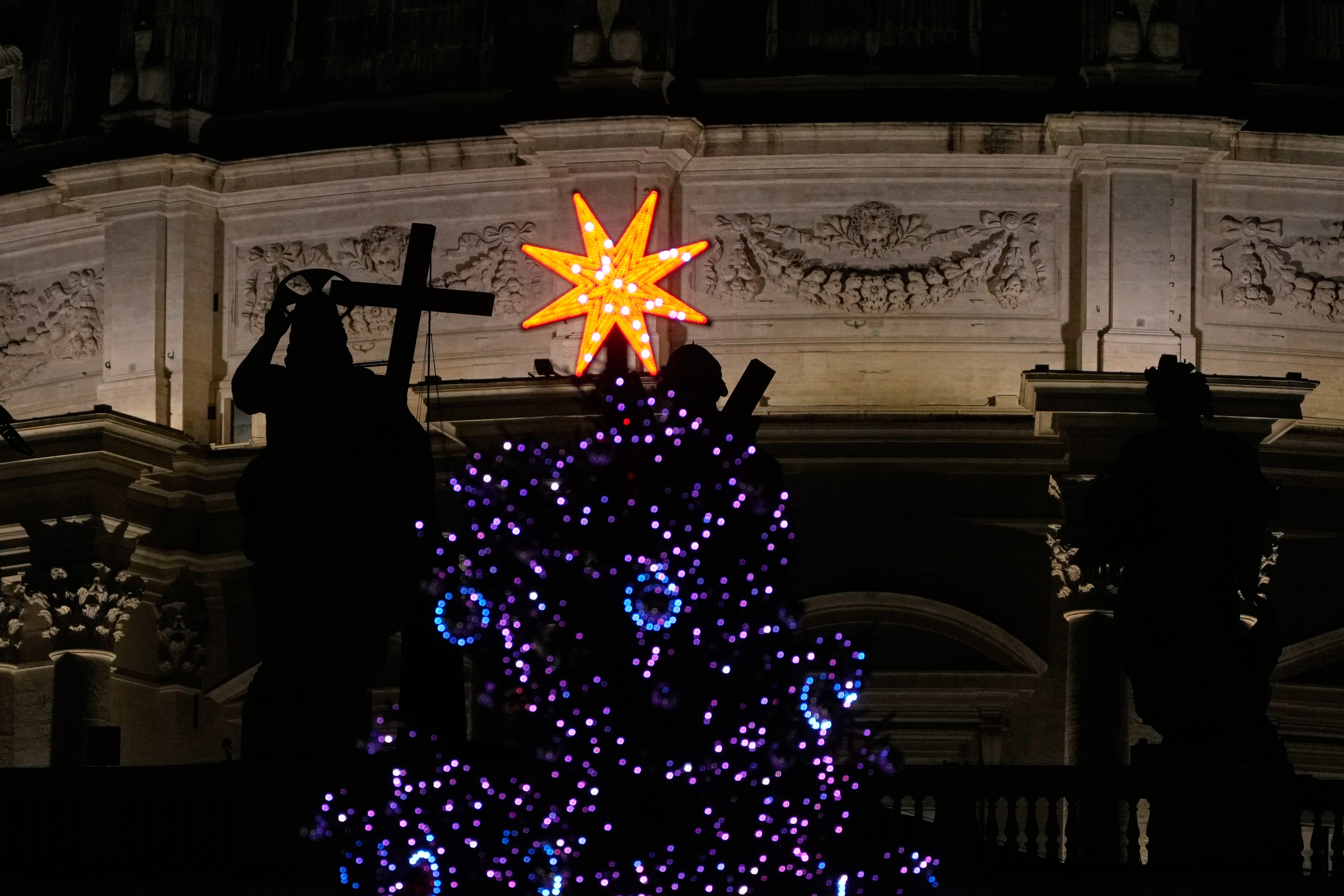 The lit Christmas tree is backdropped by the St. Peter's Basilica at the Vatican, Thursday, Jan. 8, 2026. (AP Photo/Gregorio Borgia)