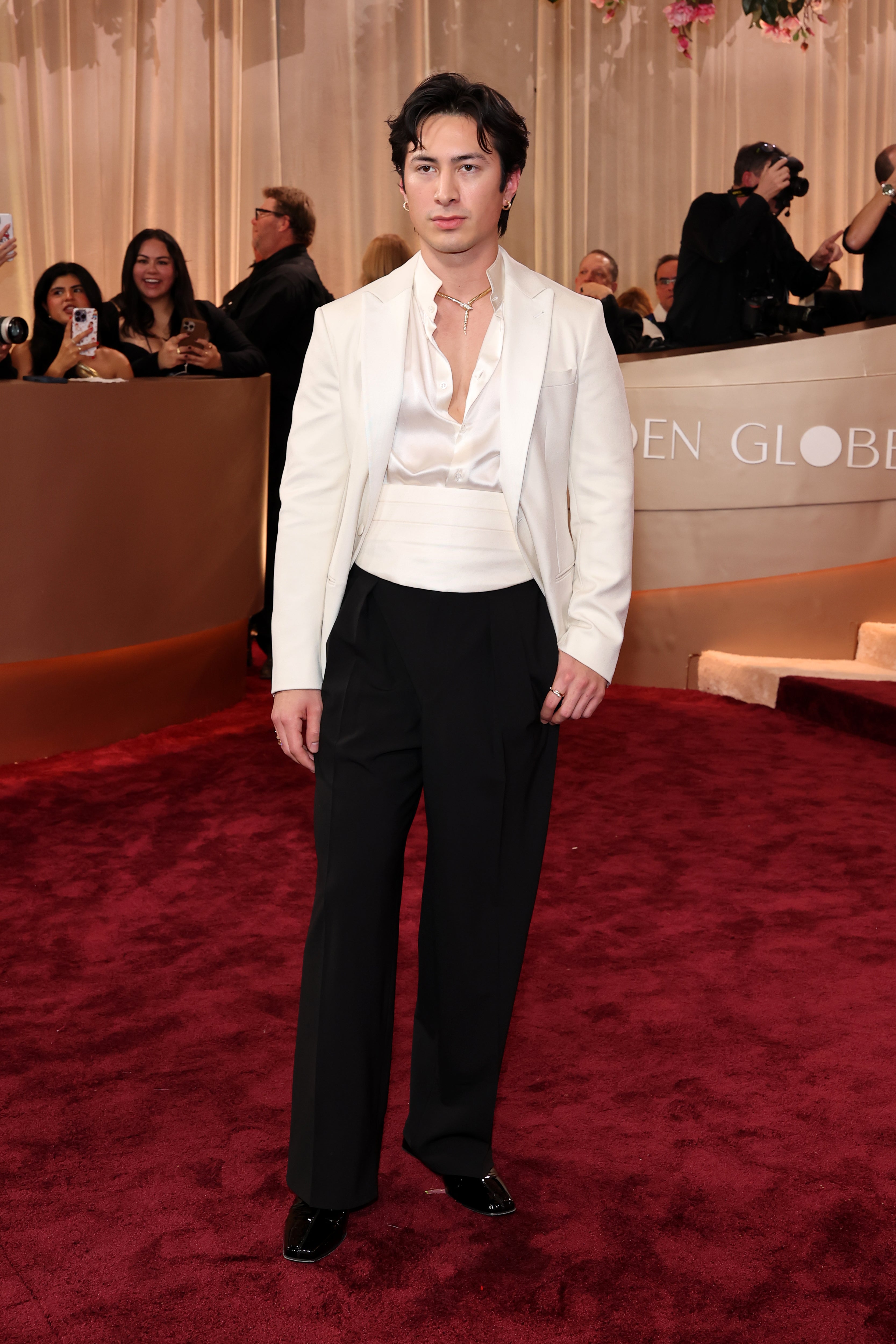 ‘Heated Rivalry’ star Hudson Williams wore a simple but timeless ensemble: a white satin shirt (with many buttons undone) and matching jacket with black pants