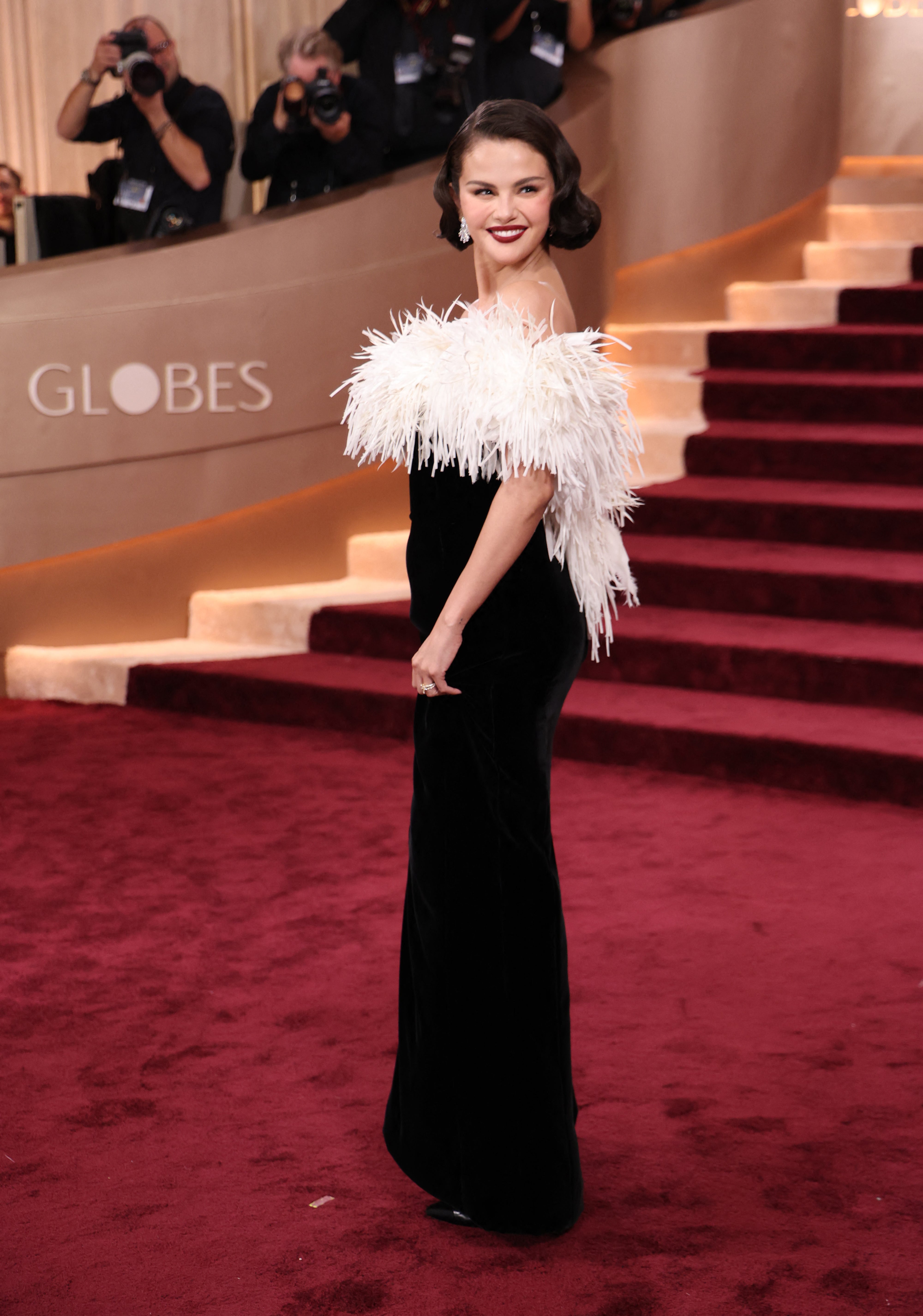 Selena Gomez stole the show in a black Chanel gown with white feathers and her black hair in a bob. She also opted for dark red lipstick and diamond earrings