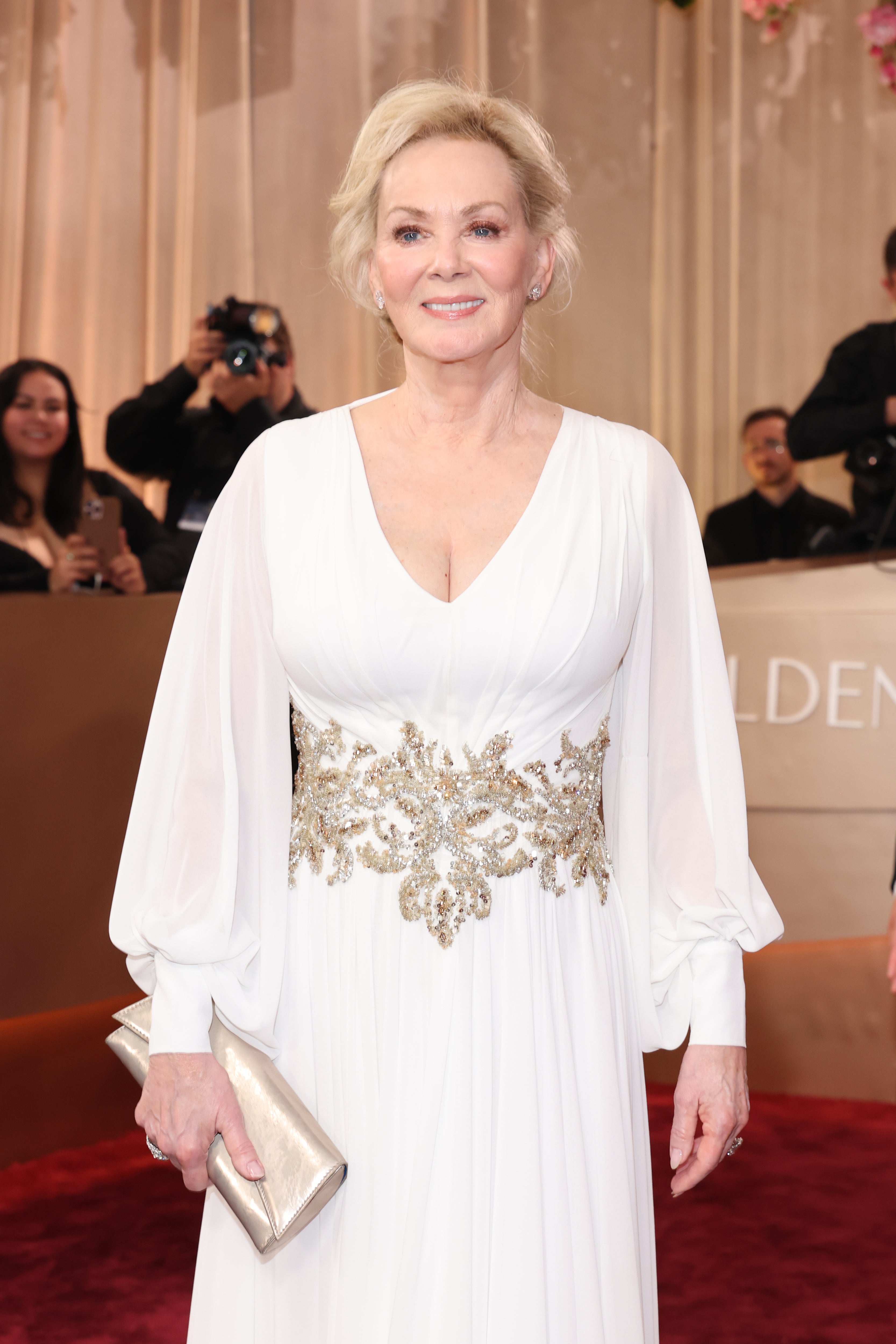 Jean Smart looked chic in a white long-sleeved dress and gold belt with a matching gold clutch