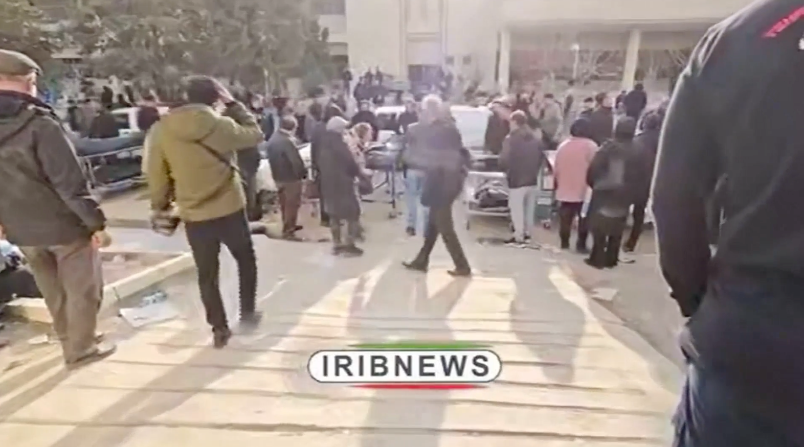 <p>Mourners move between the dead who are laid out inside several warehouses and even along an internal road in Tehran</p>