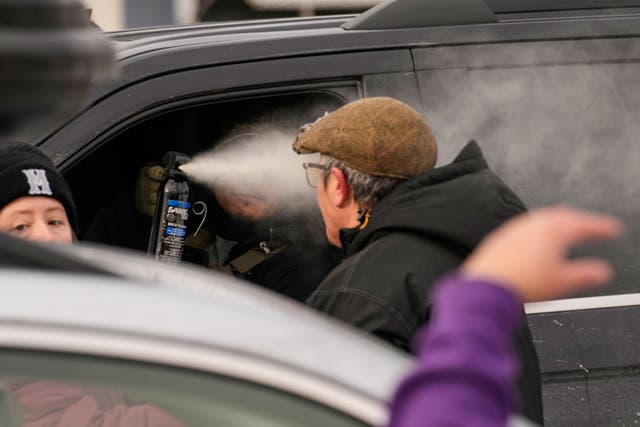 <p>A federal immigration officer deploys pepper spray as officers make an arrest Sunday, Jan. 11, 2026, in Minneapolis. (AP Photo/John Locher)</p>