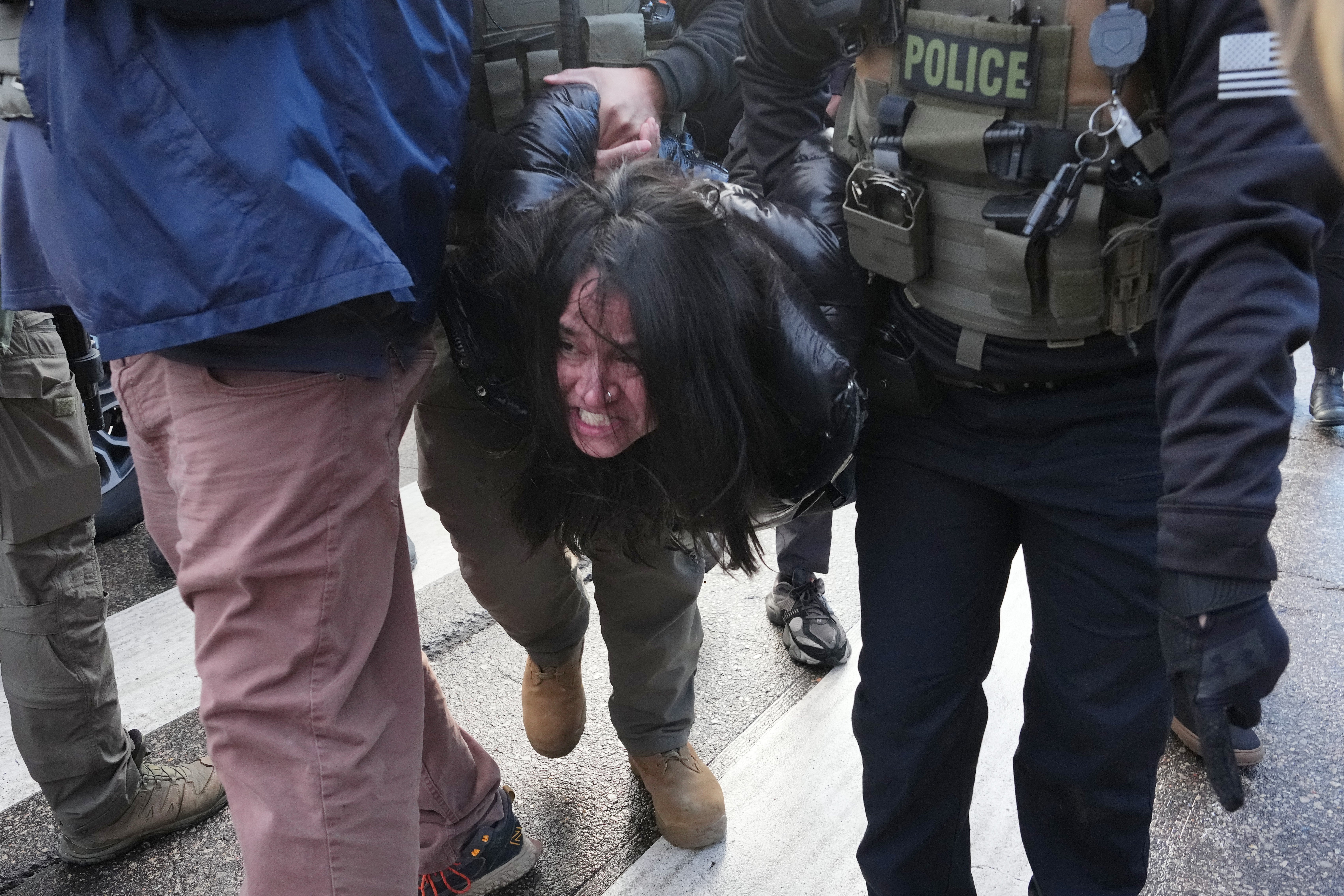 A protester is detained by federal agents near the scene where Renee Good was fatally shot by an ICE officer last week, Tuesday, Jan. 13, 2026, in Minneapolis. (AP Photo/Adam Gray)