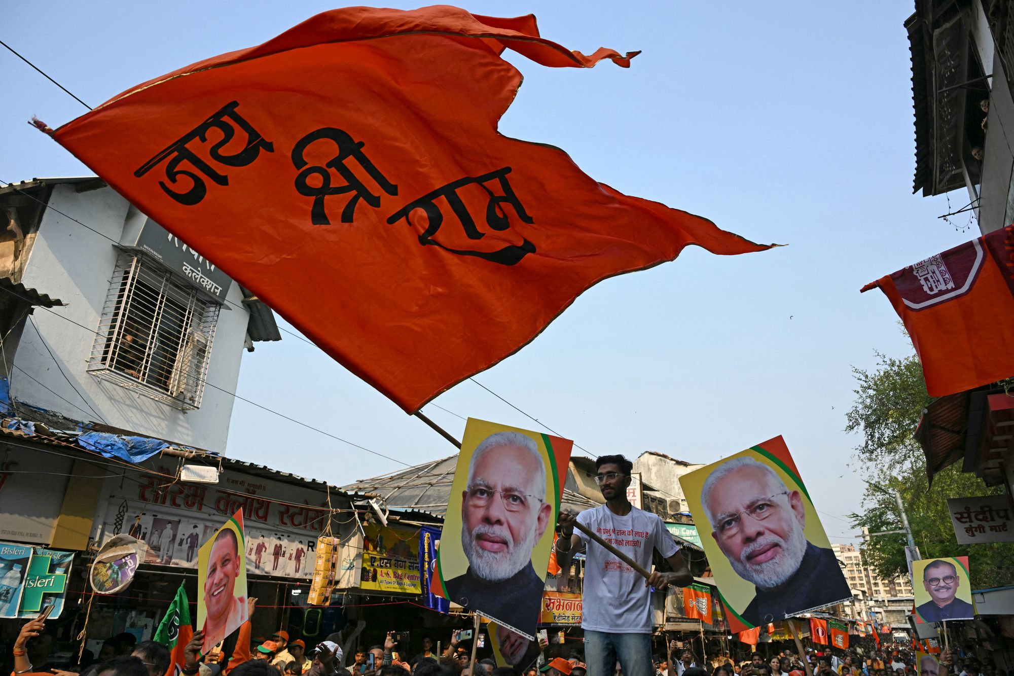 File. A supporter waves a saffron flag that says ‘Jai Shri Ram’ (Glory to Lord Ram) next to the posters of India’s prime minister and leader of the ruling Bharatiya Janata Party (BJP), Narendra Modi