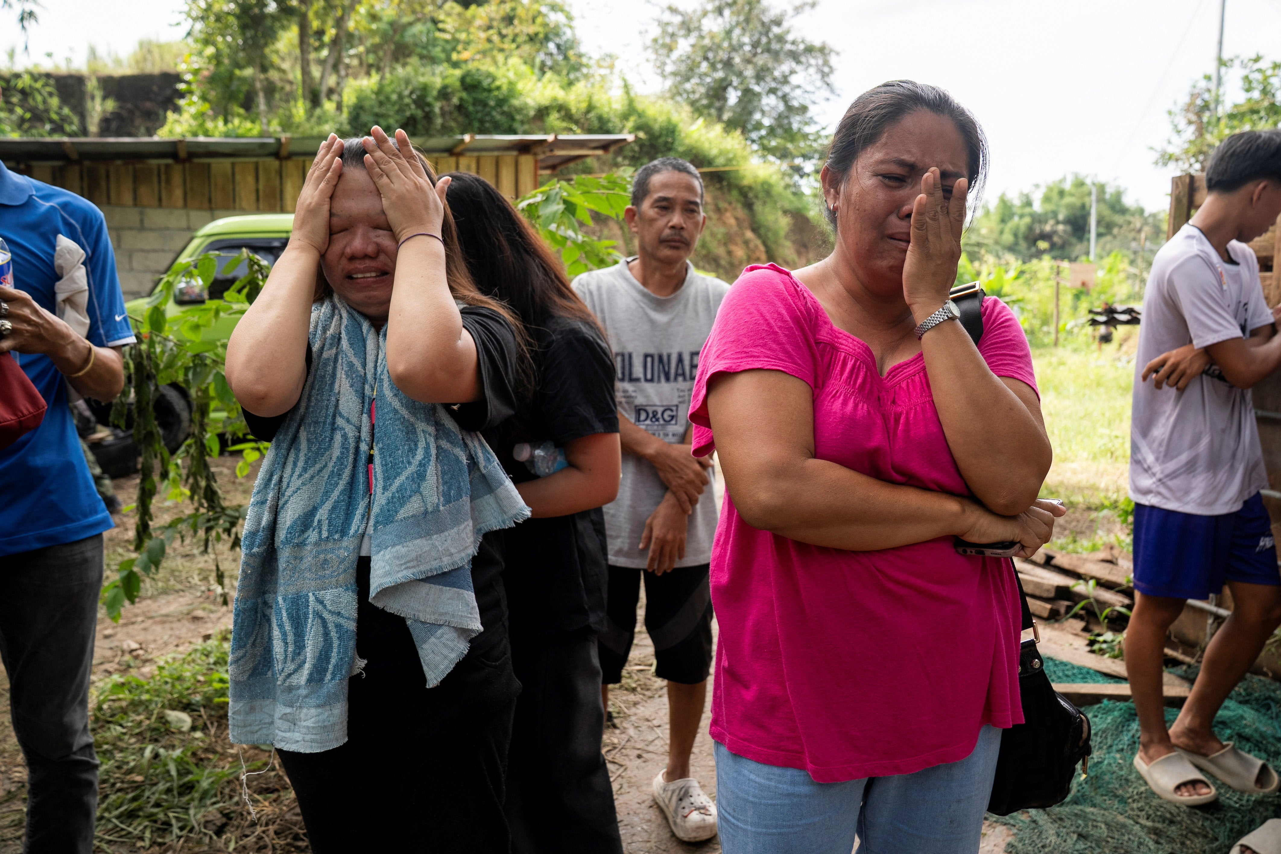 Family members and relatives of missing individuals react while rescue workers conduct a rescue operation at the collapsed landfill in Binaliw, Cebu, Philippines, 11 January 2026