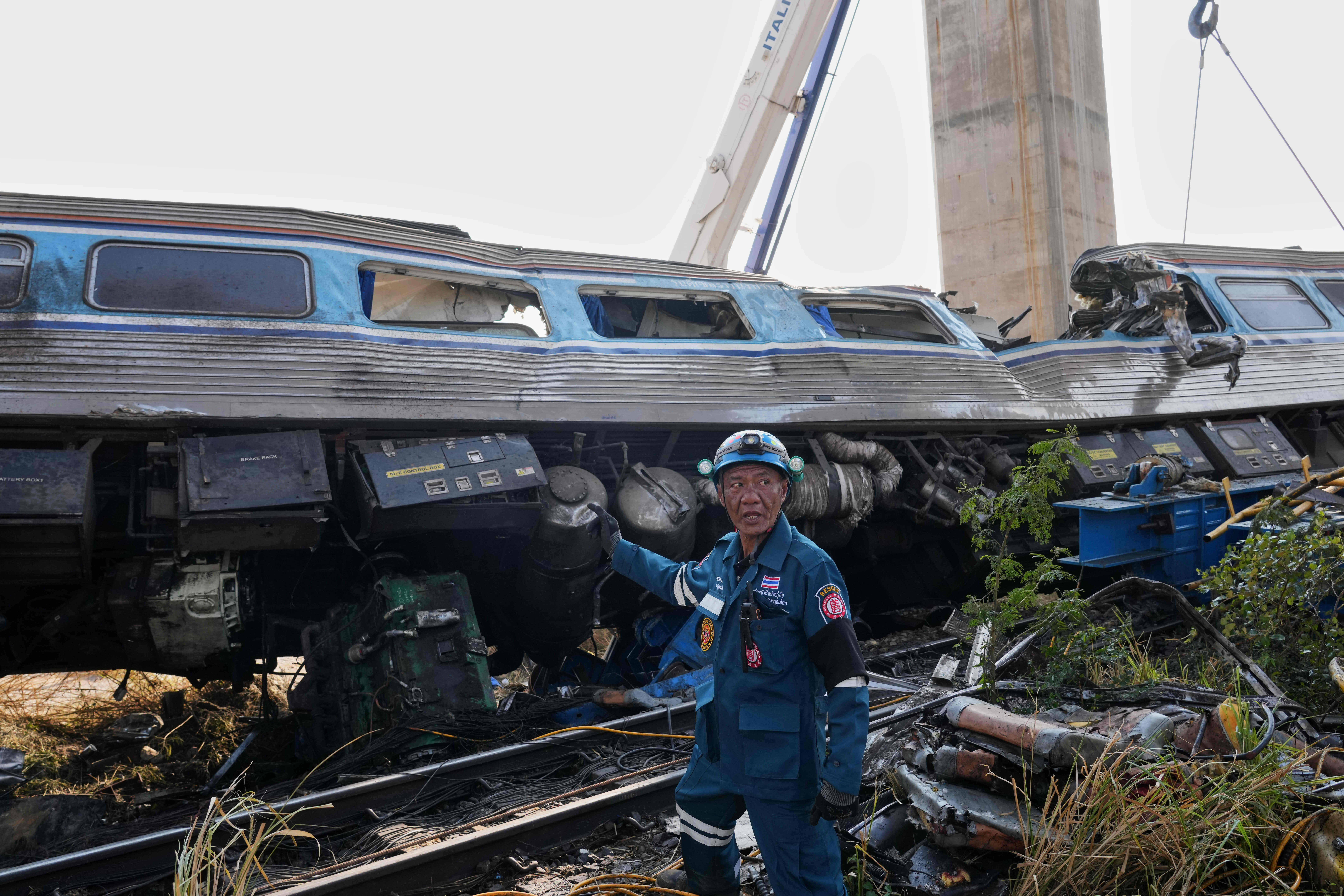A rescuer stands near the wreckage.