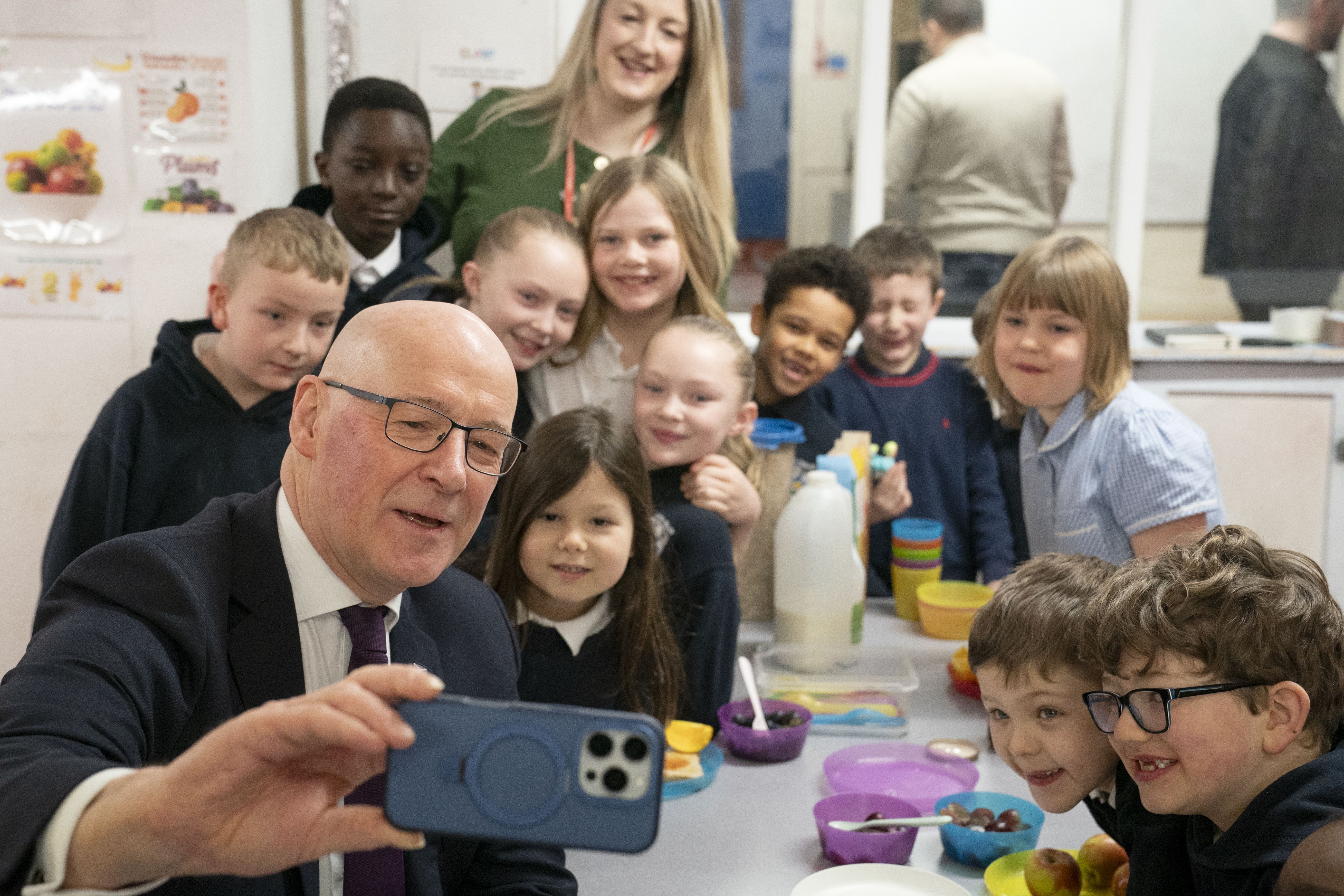 First Minister John Swinney highlighted the support for families the Budget offers as he visited a primary school breakfast club (Jane Barlow/PA)