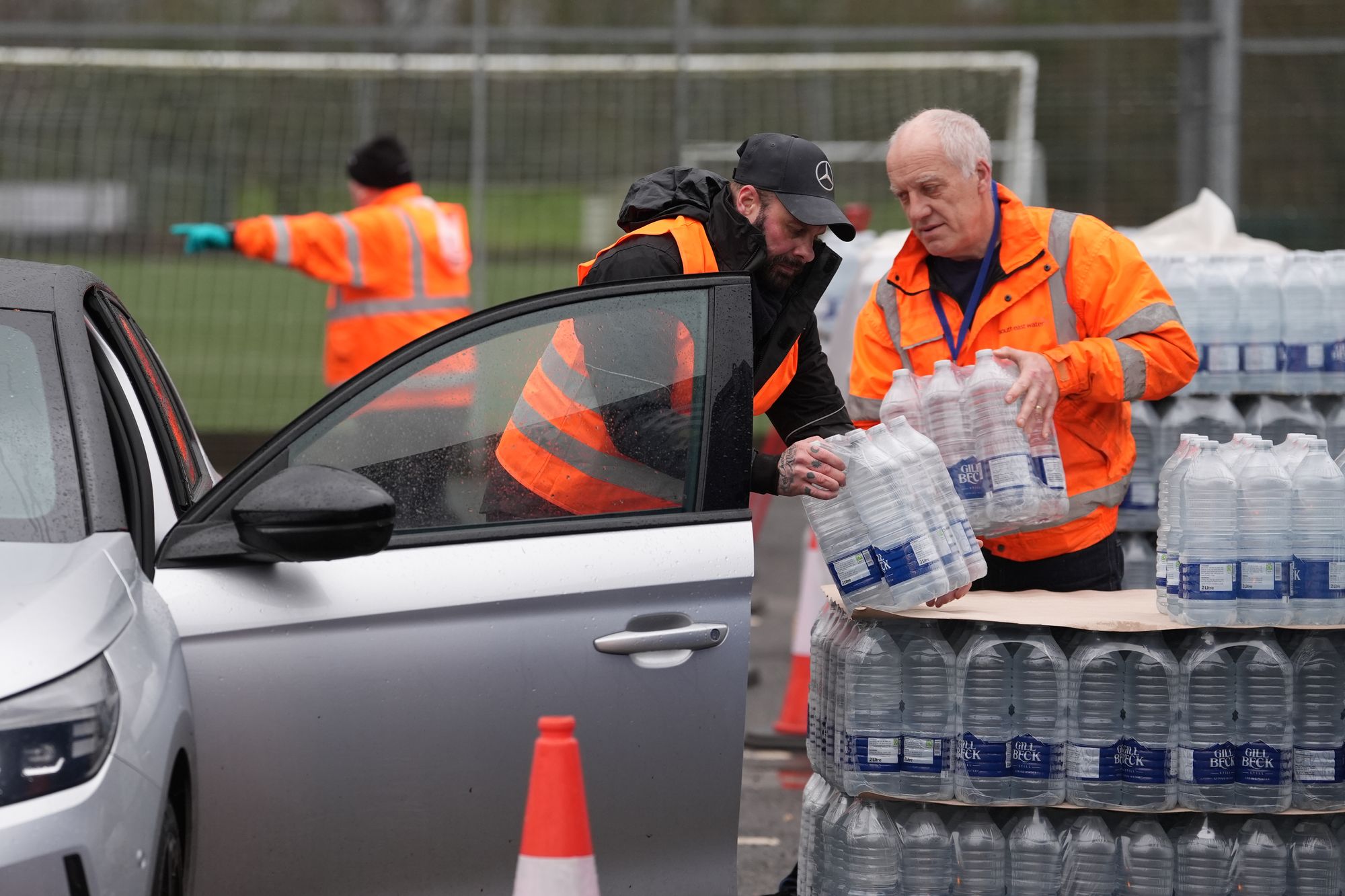 Workers hand over bottled water at a water station in East Grinstead, after bad weather was blamed for more water outages in Kent and parts of Sussex