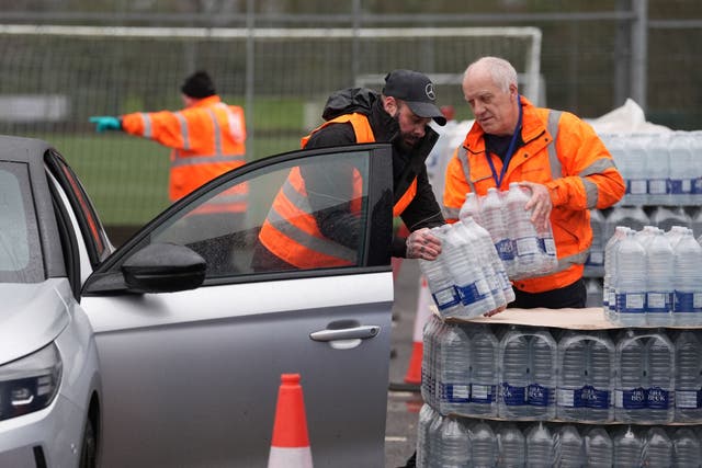 <p>Workers hand over bottled water at a water station in East Grinstead, after bad weather was blamed for more water outages in Kent and parts of Sussex</p>